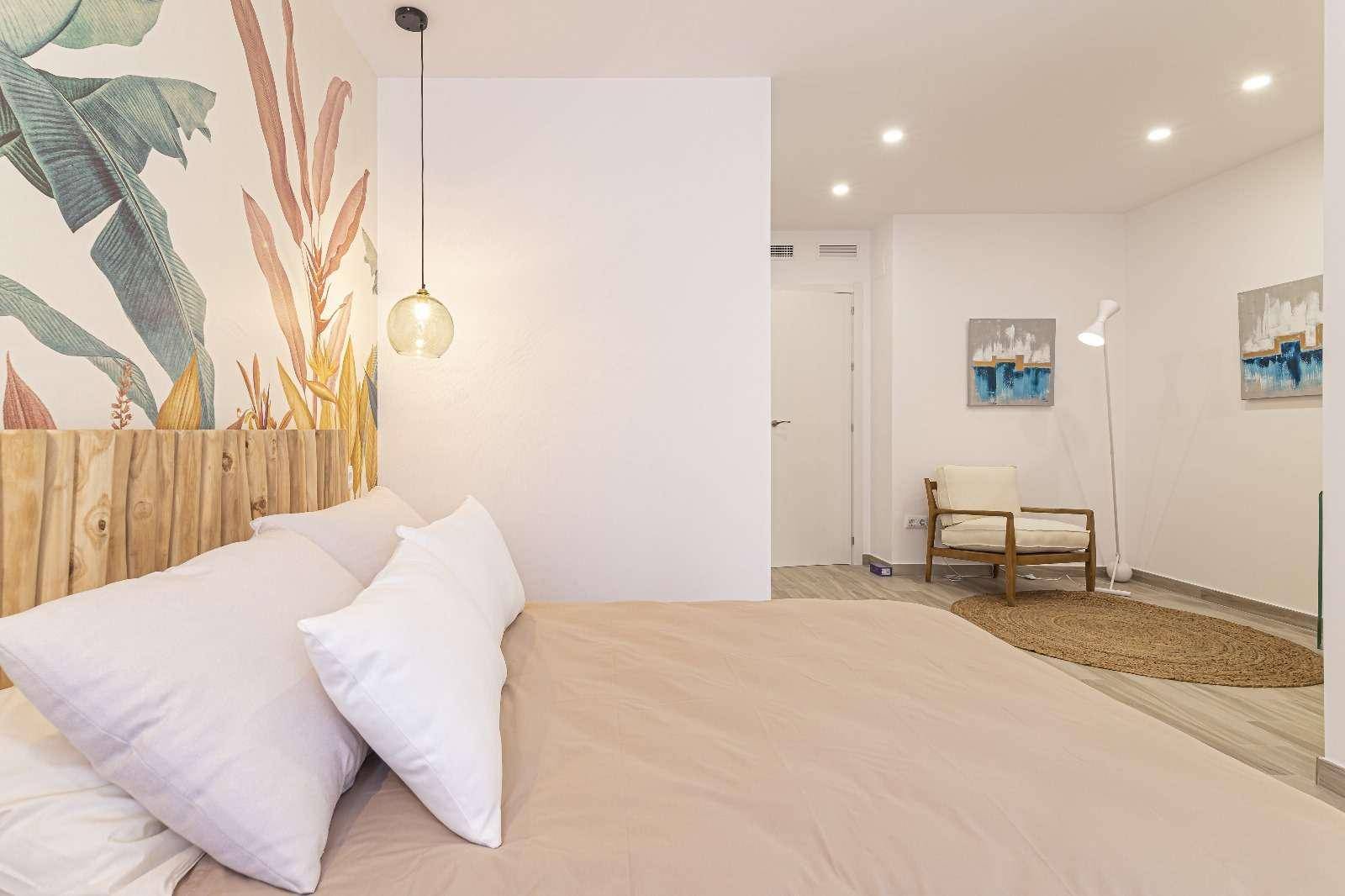 Modernes Schlafzimmer mit Holzbett, farbenfroher Wandgestaltung und viel Tageslicht.