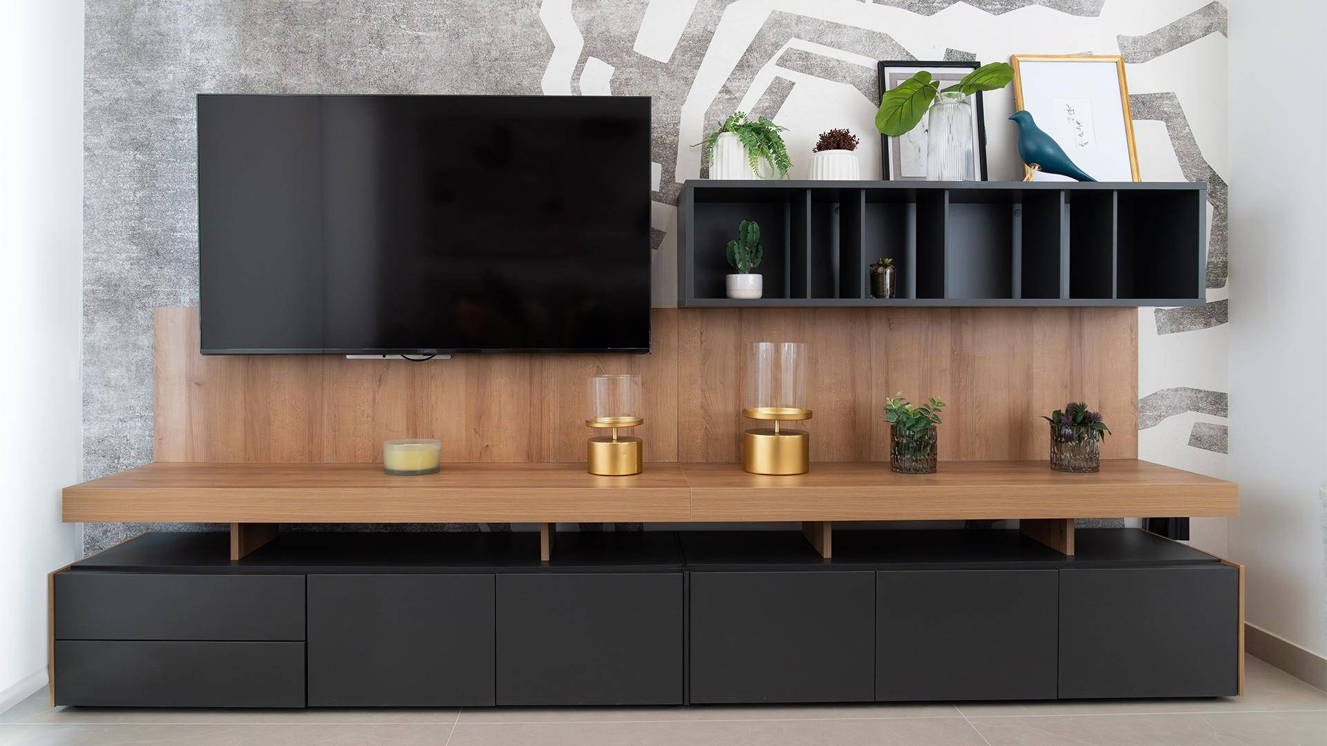 Moderne TV-Wand mit Holz- und Schwarzakzenten, integrierten Regalen und Dekoration.