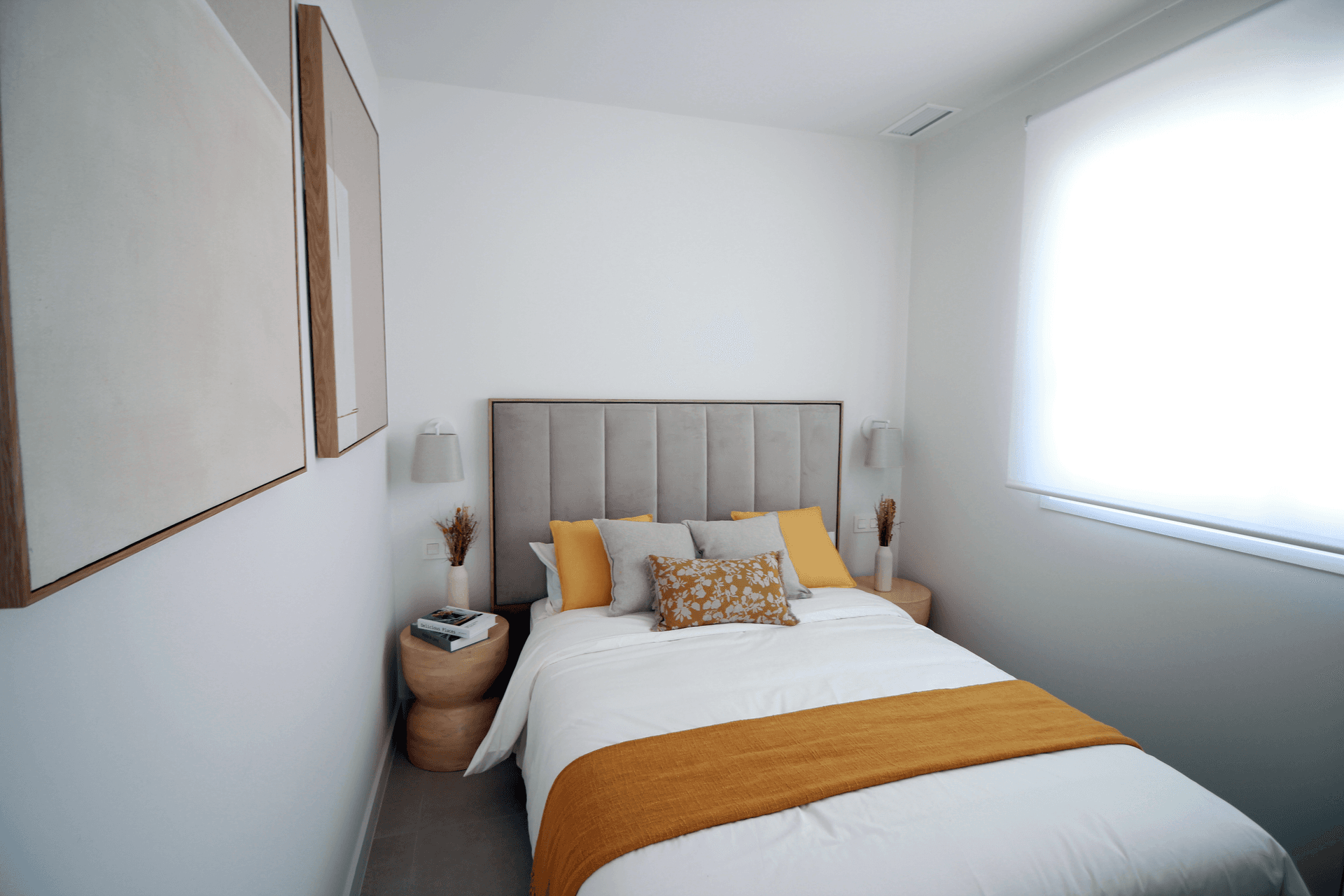 Modernes Schlafzimmer mit Doppelbett, gepolstertem Kopfteil und minimalistischer Dekoration.
