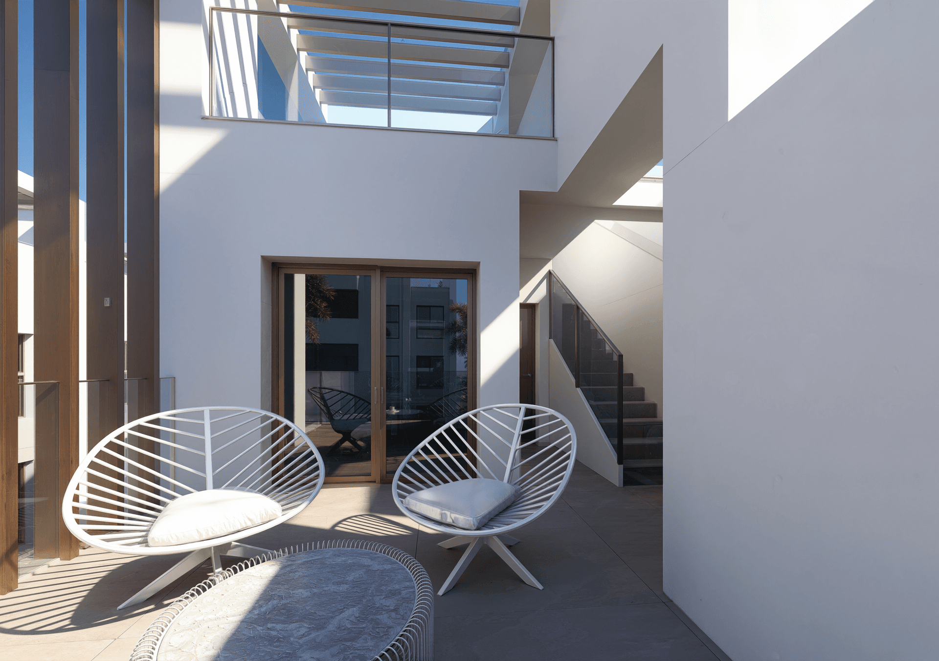 Moderne Terrasse mit bequemen Outdoor-Sesseln und Blick auf die Umgebung.