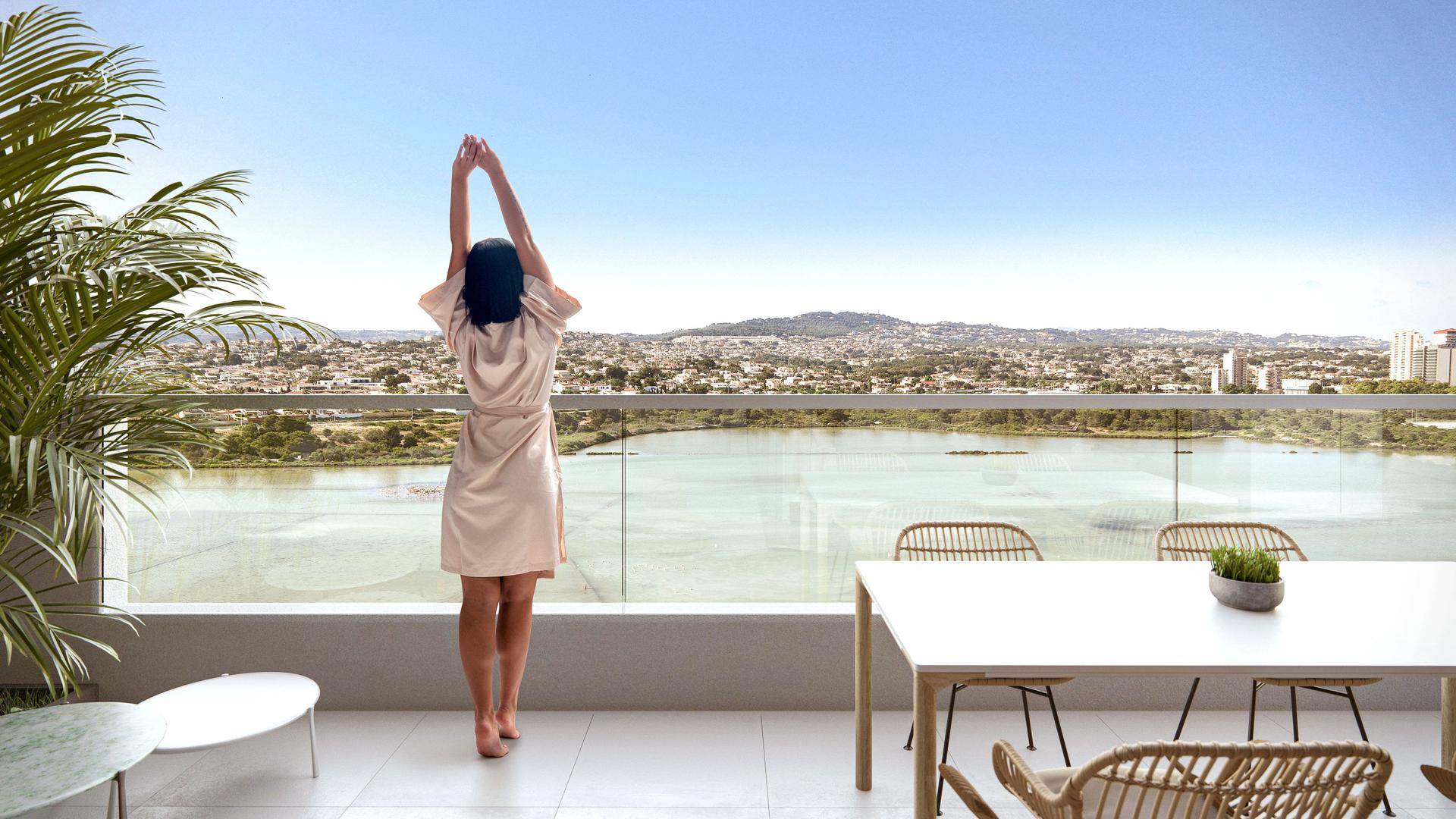Balkon mit Esstisch und weitem Blick über das Wasser und die umliegende Landschaft.