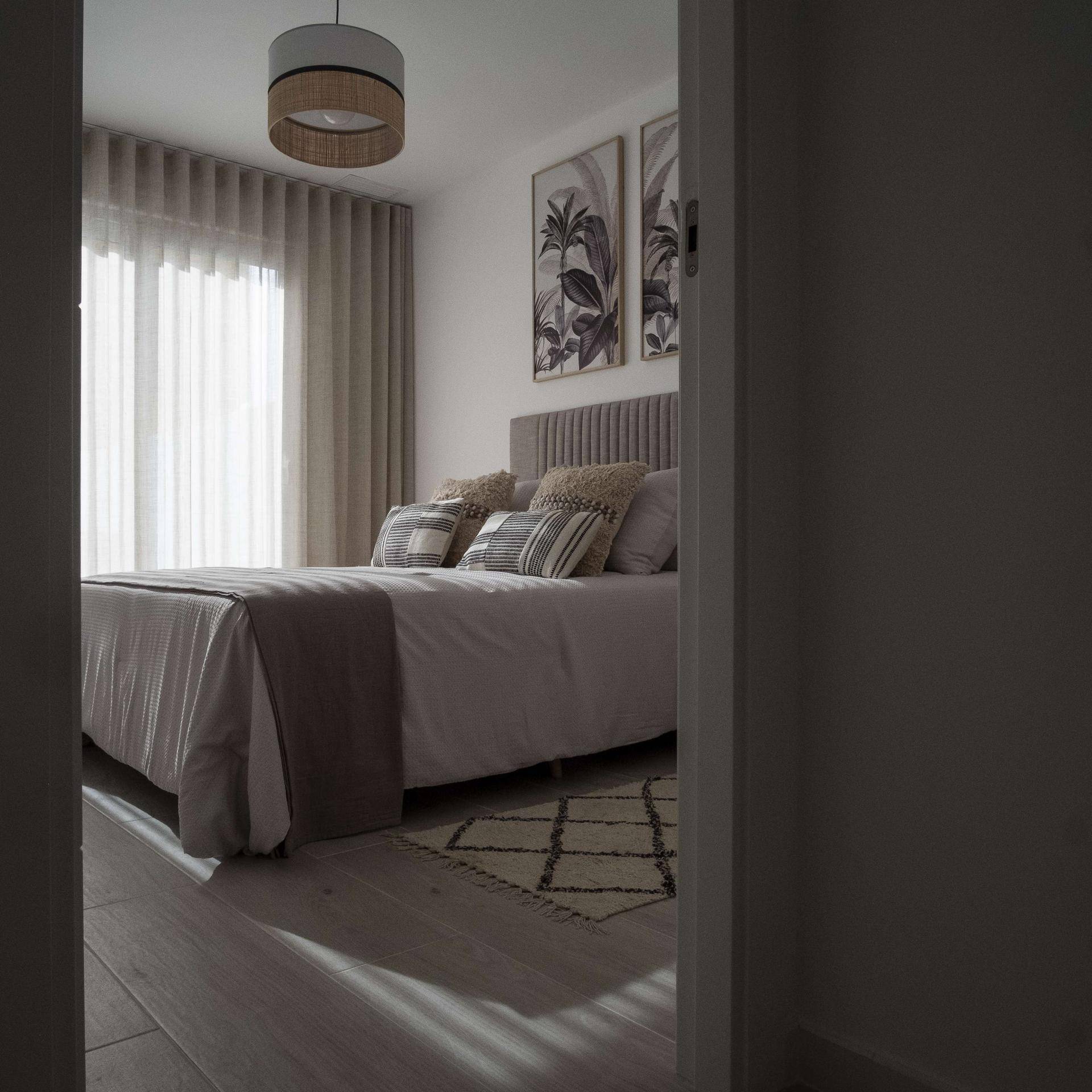 Blick in ein helles Schlafzimmer mit Doppelbett und stilvoller Einrichtung.