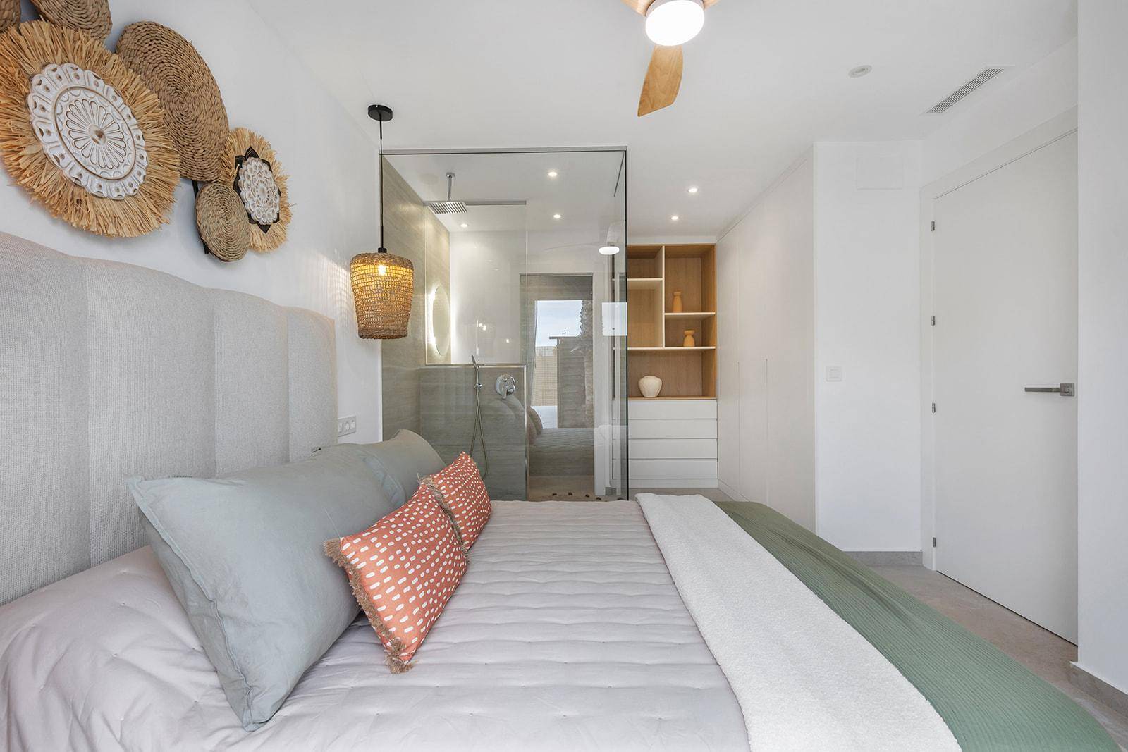 Schlafzimmer mit offenem Duschbereich, modernen Regalen und viel Tageslicht.