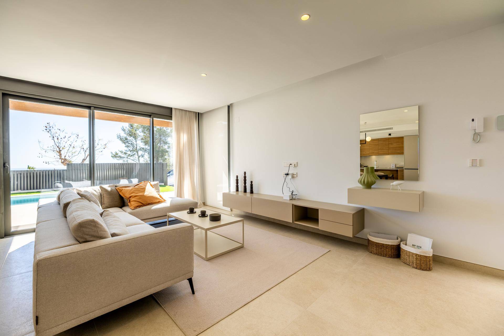 Modern eingerichtetes Wohnzimmer mit beiger Eckcouch, minimalistischem TV-Möbel und viel Tageslicht.