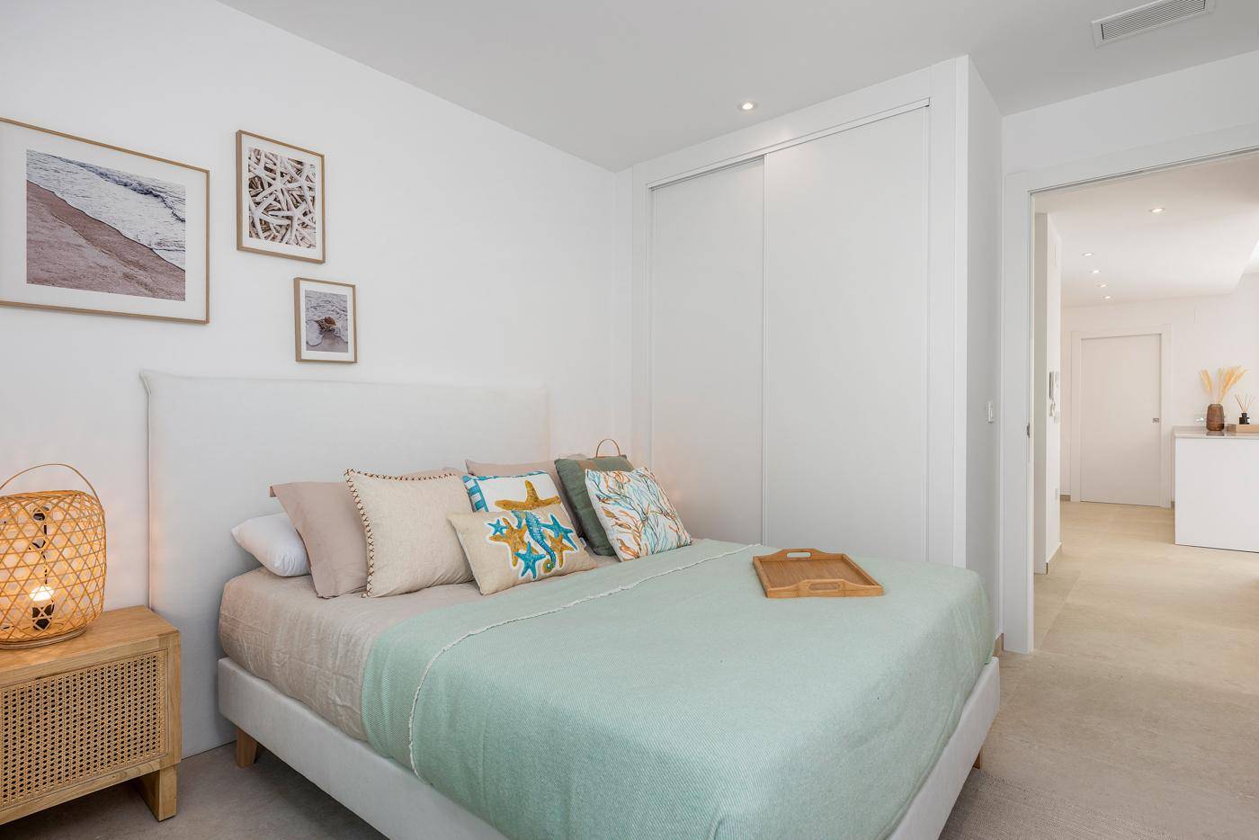 Schlafzimmer mit Einbauschränken und Zugang zu einem modernen Badezimmer.
