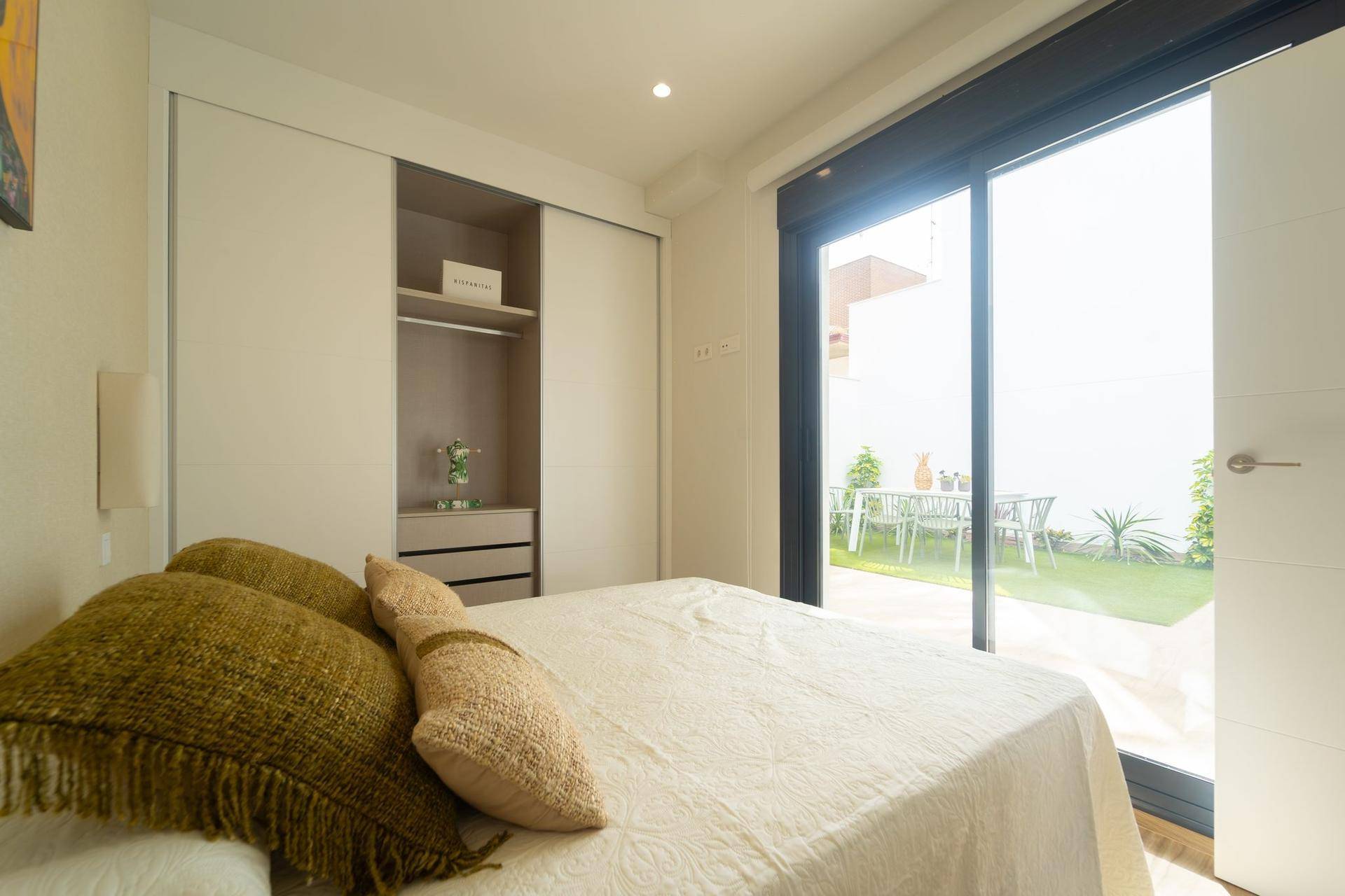 Gemütliches Schlafzimmer mit Einbauschränken und direktem Zugang zum privaten Gartenbereich.