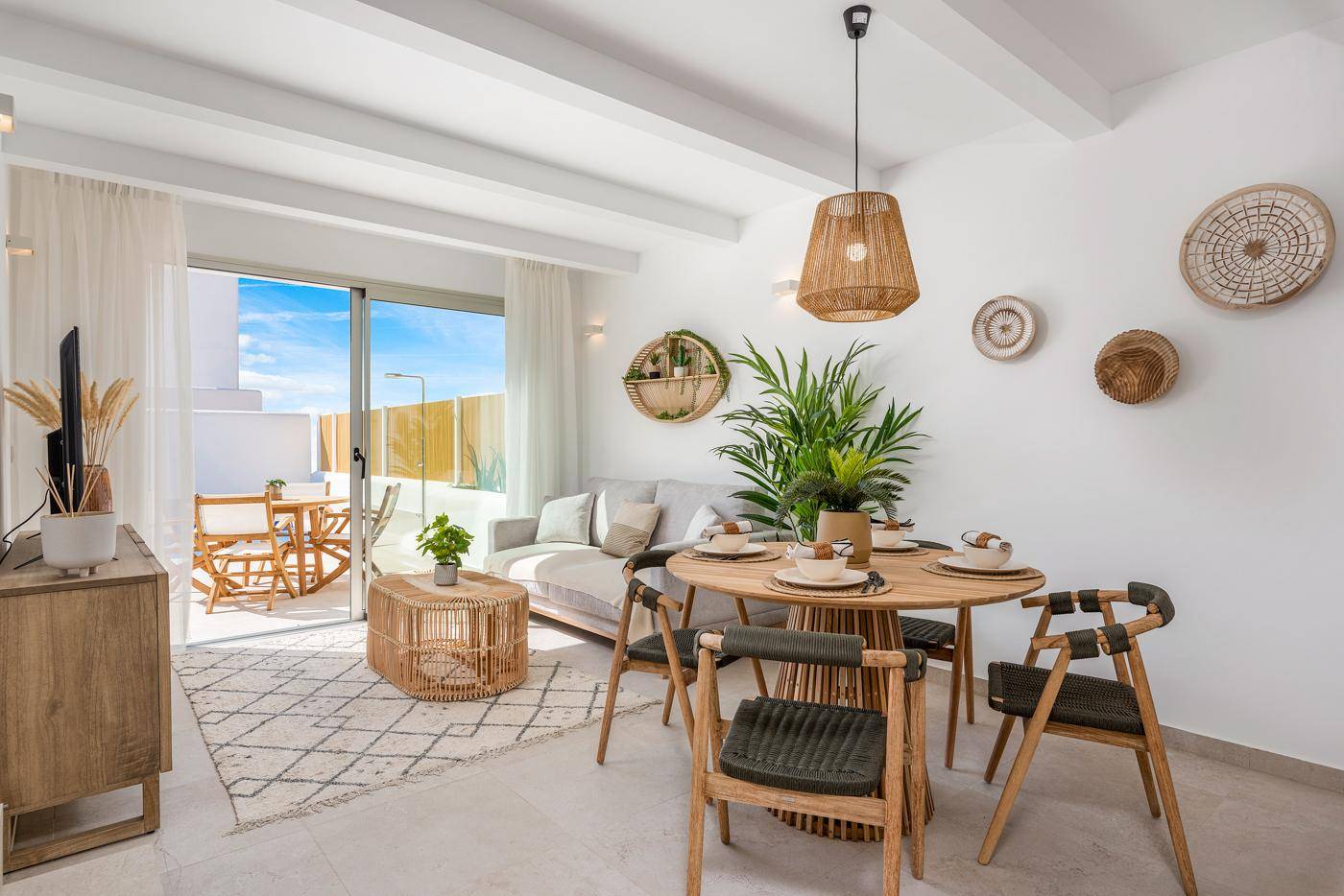 Heller Wohn-Essbereich mit modernem Esstisch, Sofa und Zugang zur Terrasse.