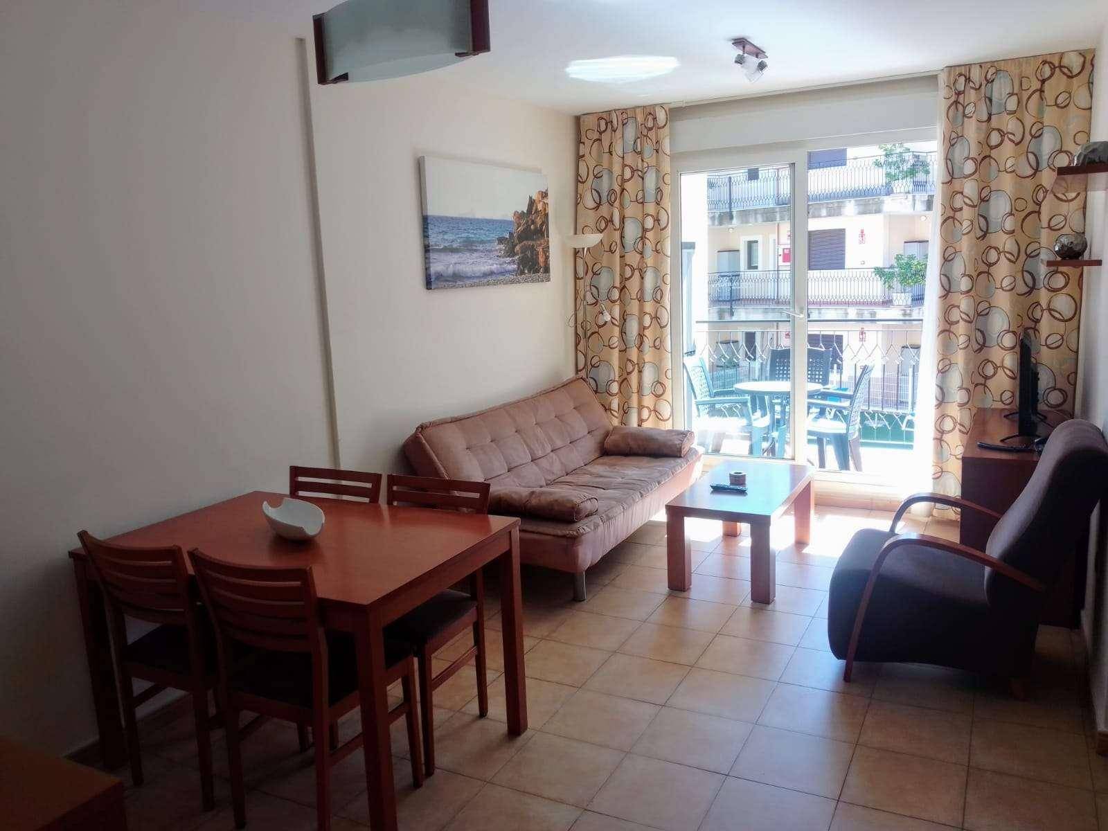 Gemütlicher Wohn- und Essbereich mit Zugang zu einem Balkon und Blick nach draußen.