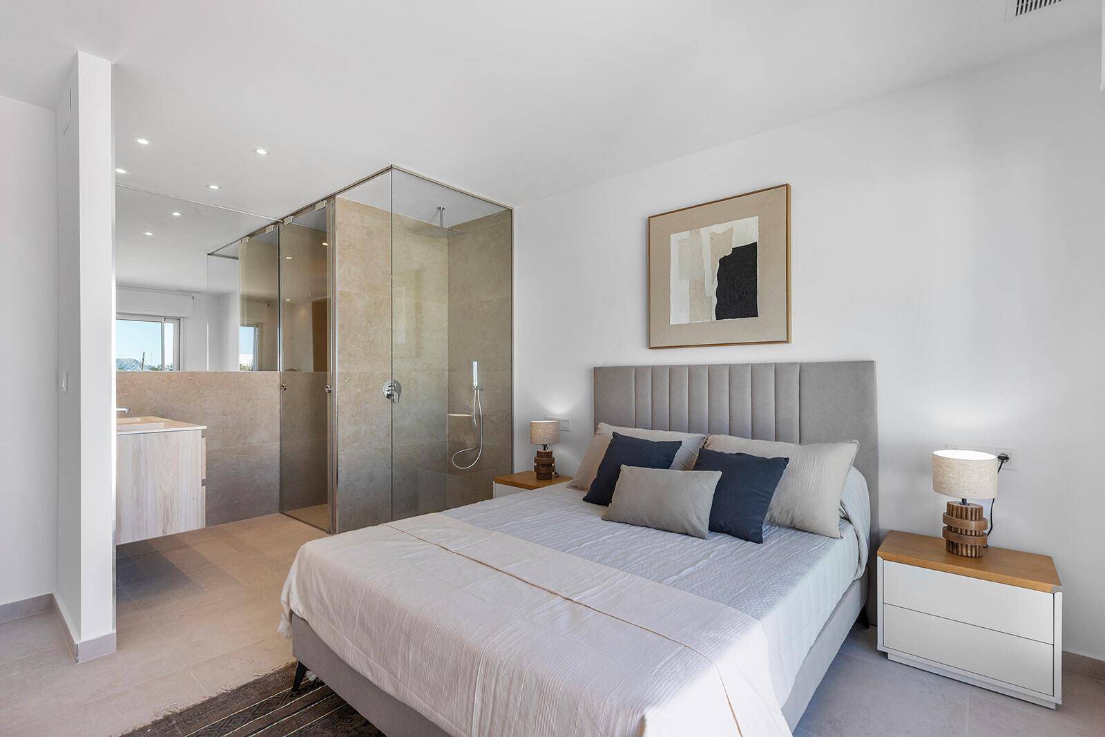 Schlafzimmer mit offenem Badbereich, begehbarer Dusche und modernem Design.