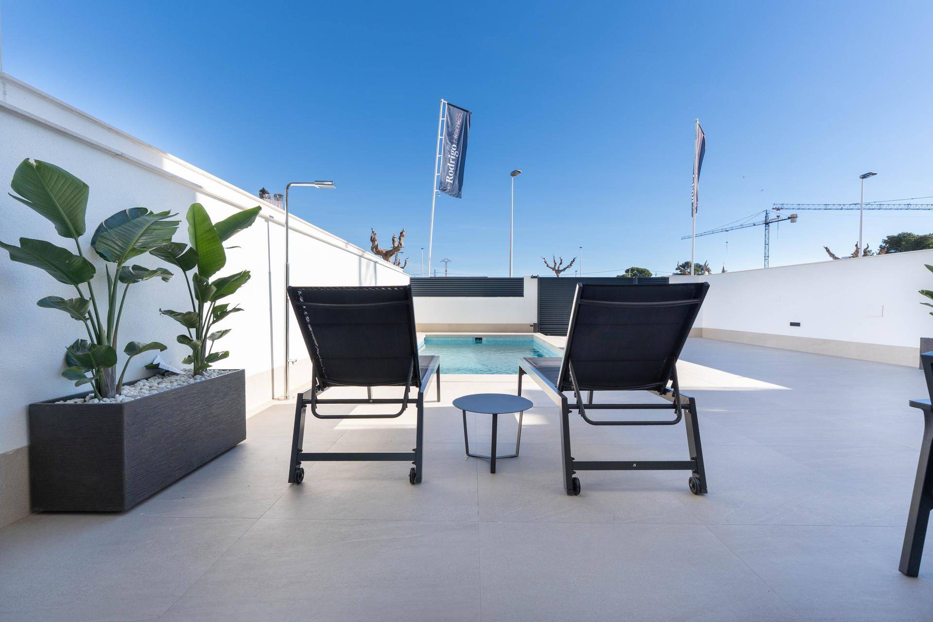 Entspannungsbereich auf der Terrasse mit Liegestühlen und Blick auf den privaten Pool.