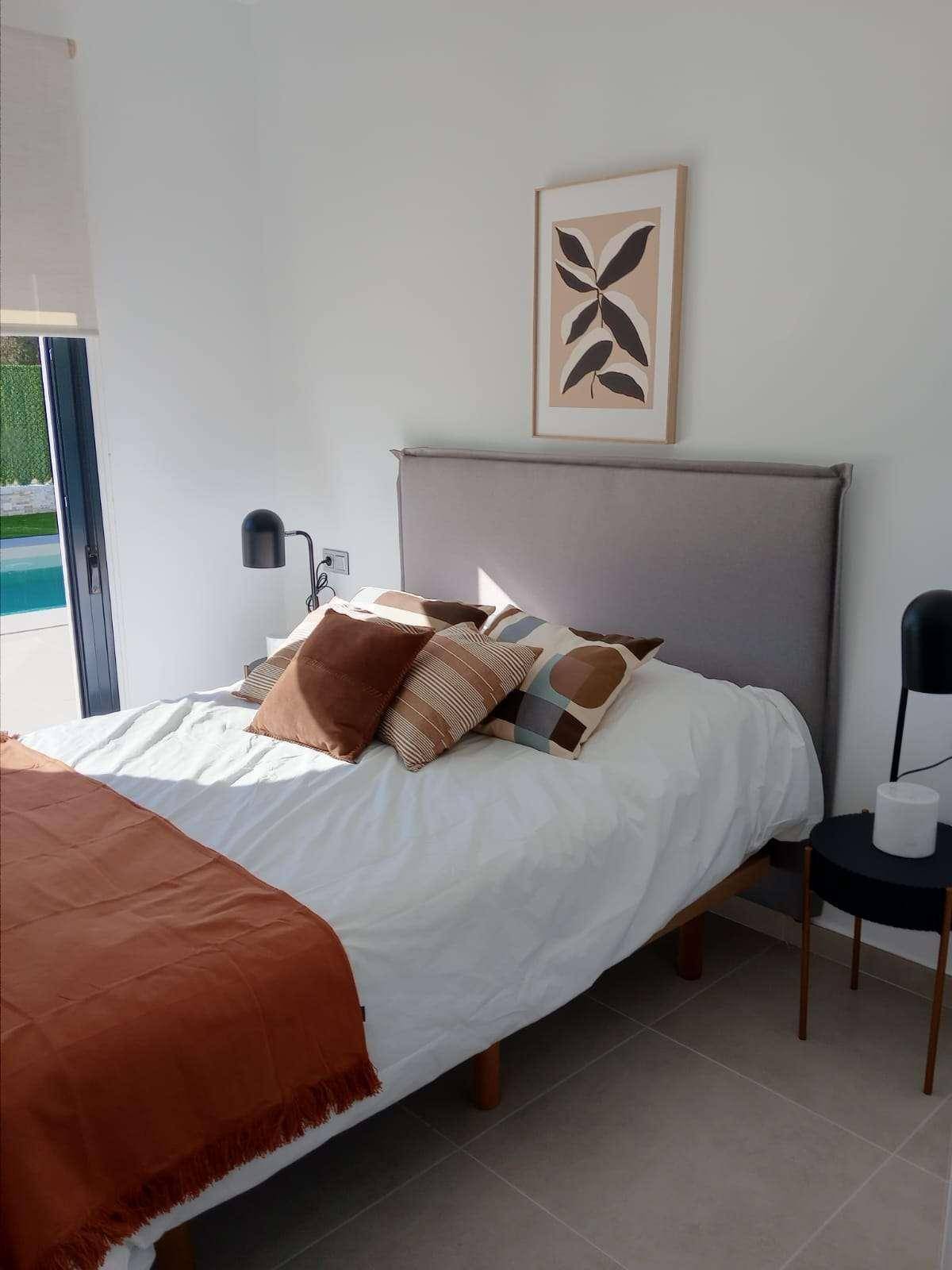 Modernes Schlafzimmer mit großem Fenster und Blick auf den Außenbereich mit Pool.