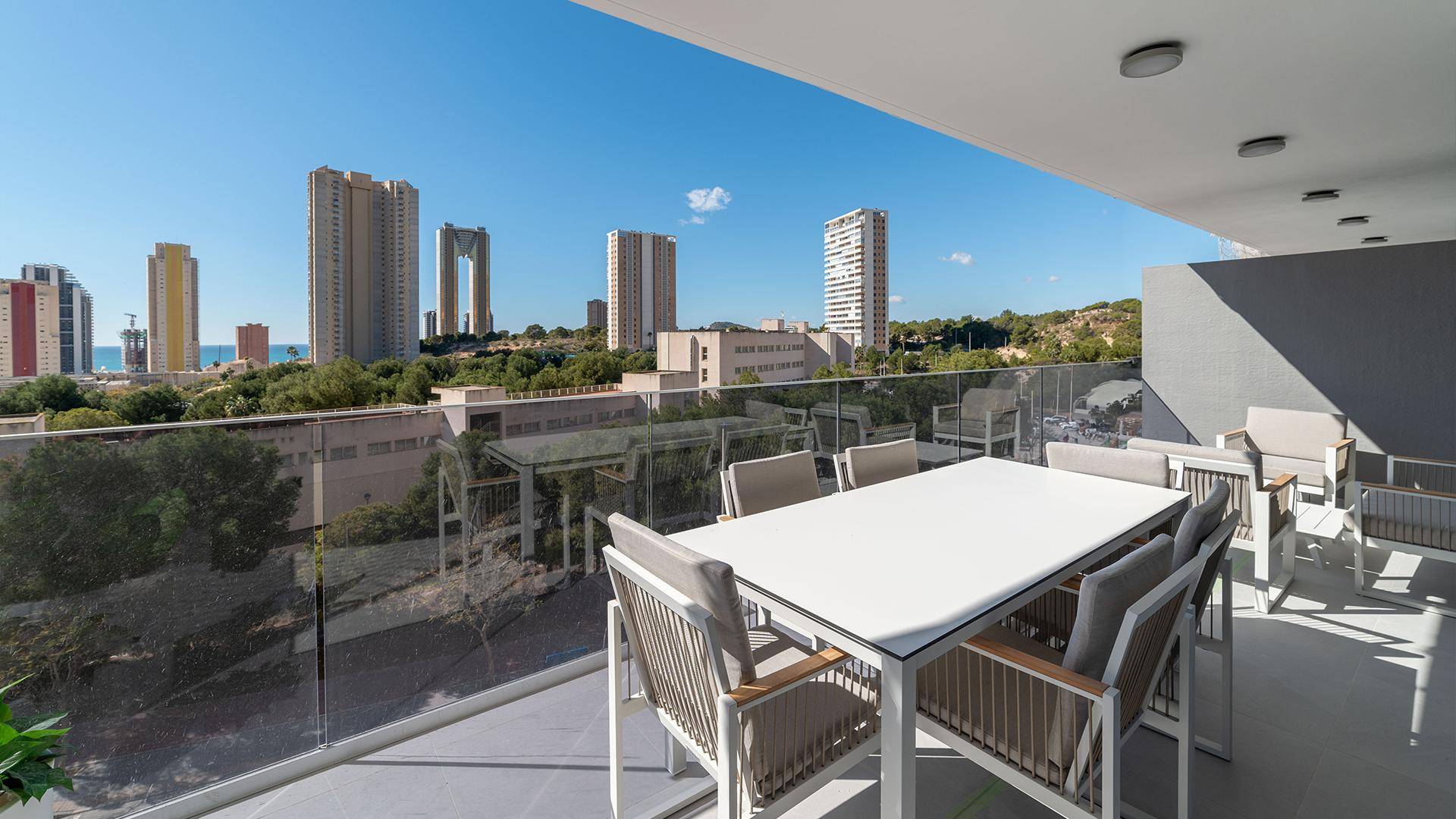Möblierte Terrasse mit Esstisch und Stühlen, bietet einen weiten Blick auf die Stadt.
