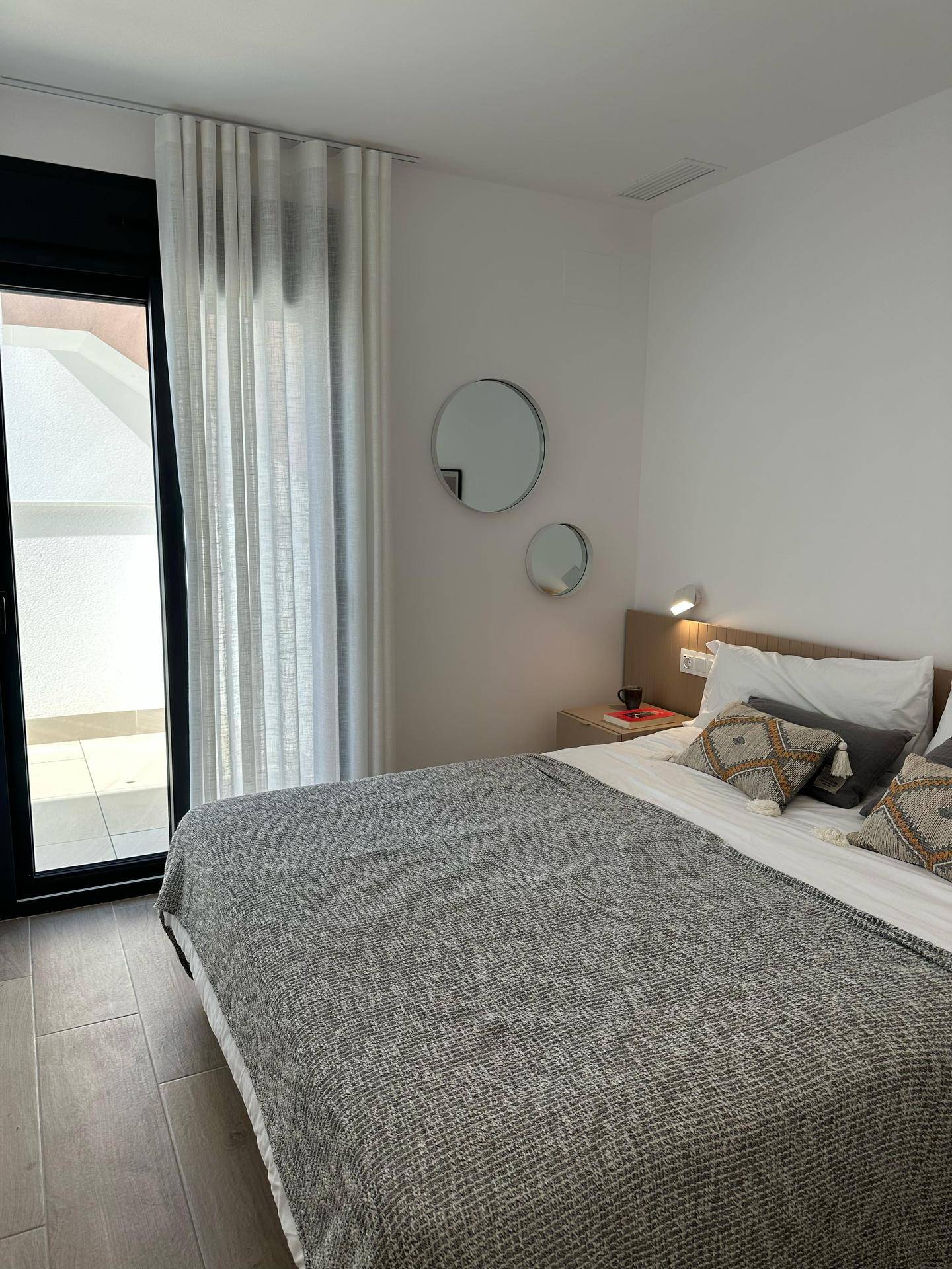 Schlafzimmer mit Doppelbett und direktem Zugang zu einem Balkon oder einer Terrasse.