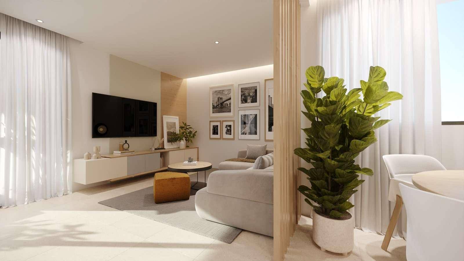 Helles, modern eingerichtetes Wohnzimmer mit beigefarbenen Fliesen, einem großen Sofa und einem Fernseher.