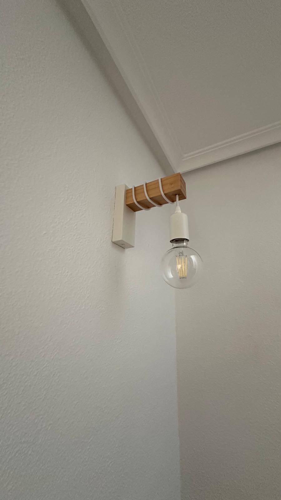 Wandleuchte mit Holzhalterung und sichtbarer Glühbirne, modernes Design.