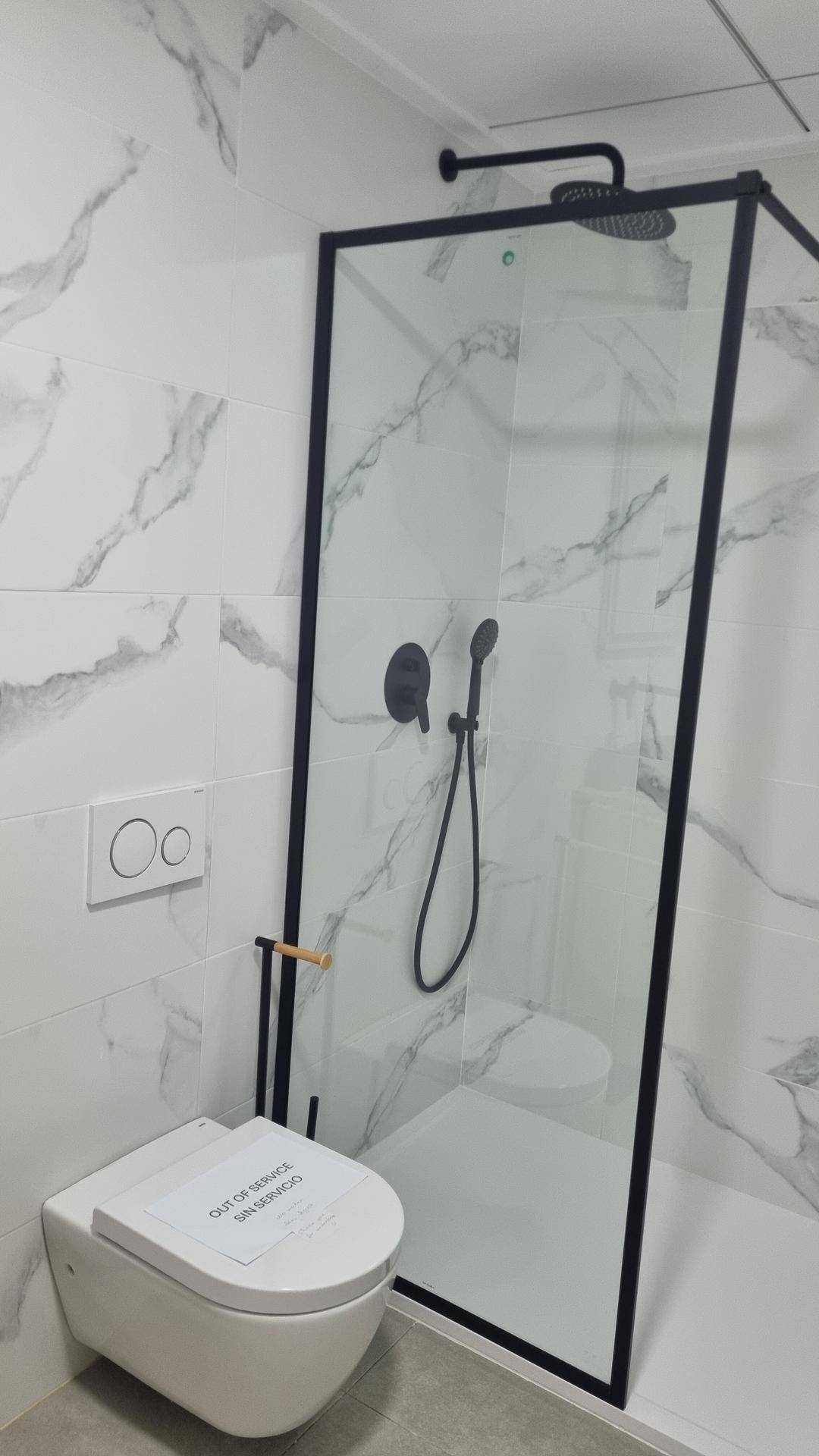 Modernes Badezimmer mit begehbarer Dusche, Wand-WC und Marmoroptik-Fliesen.