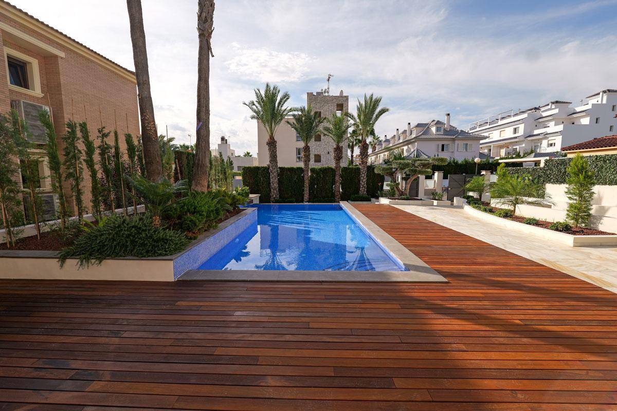 Großzügiges Holzdeck neben dem Pool, ideal zum Sonnenbaden, mit Blick auf die Umgebung.