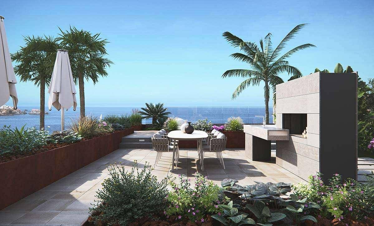 Sonniger Essbereich im Freien mit Meerblick, Grillstation und mediterraner Bepflanzung unter Palmen.