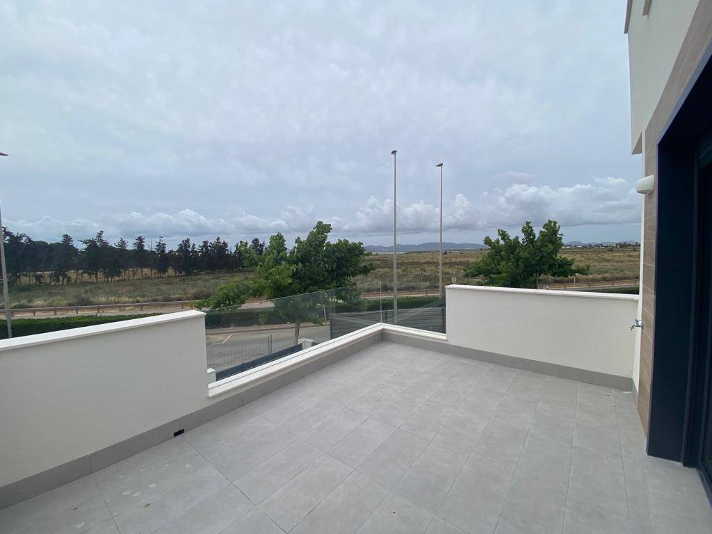 Geräumige Dachterrasse mit Fliesenboden und Glasgeländer, bietet weite Aussicht.