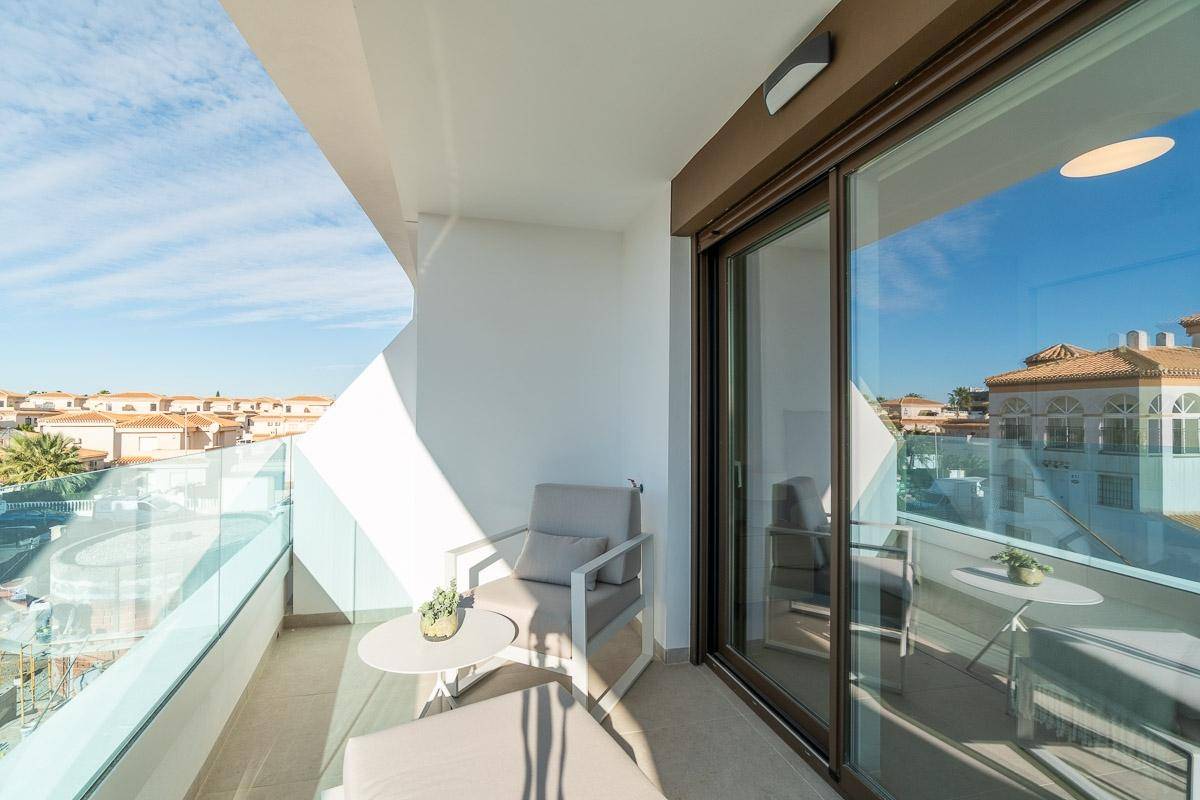 Sonniger Balkon mit bequemer Lounge-Sitzgelegenheit und weitem Blick über die Dächer.