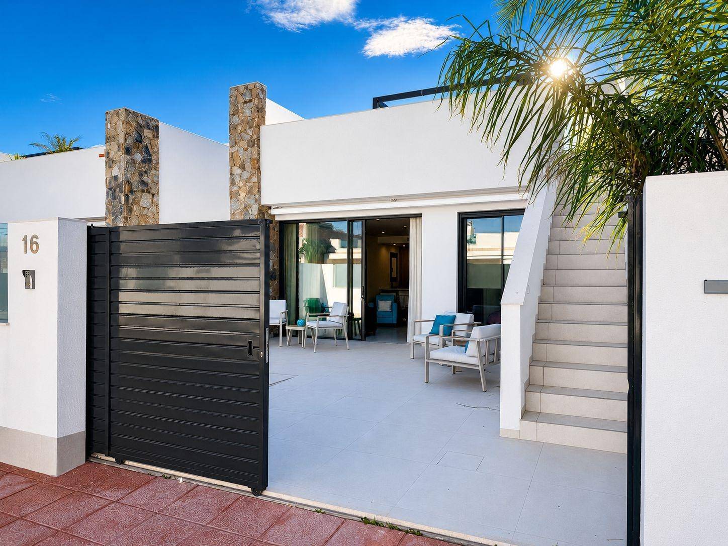 Eingangsbereich des Hauses mit privatem Tor, Terrasse und Zugang zum Poolbereich.