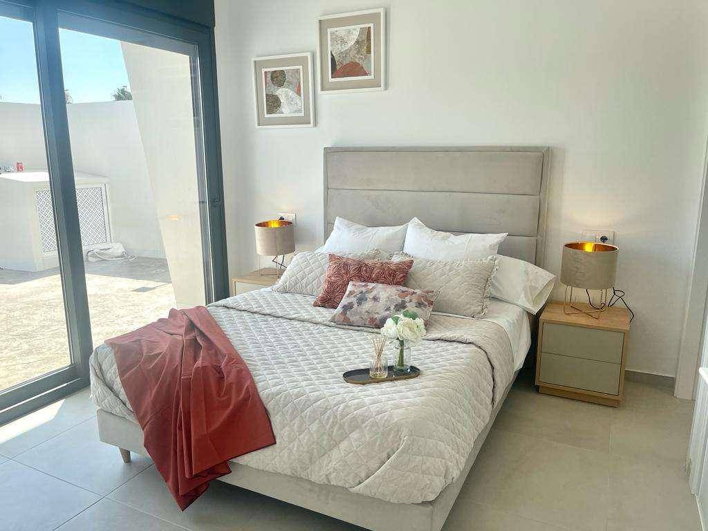 Schlafzimmer mit Doppelbett, moderner Einrichtung und direktem Zugang zur Terrasse.