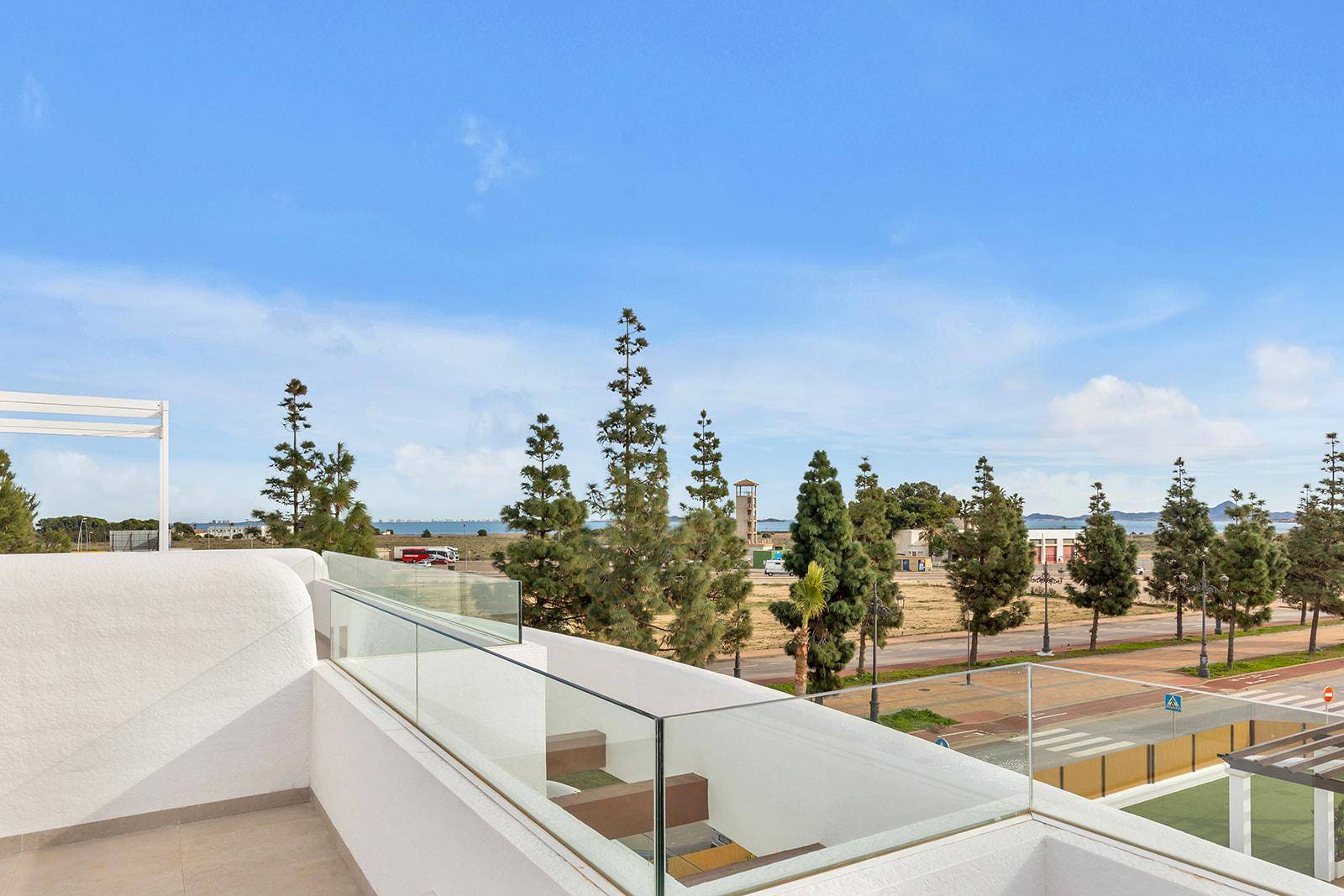 Dachterrasse mit Glasgeländer und weitem Blick auf das Meer und die Umgebung.