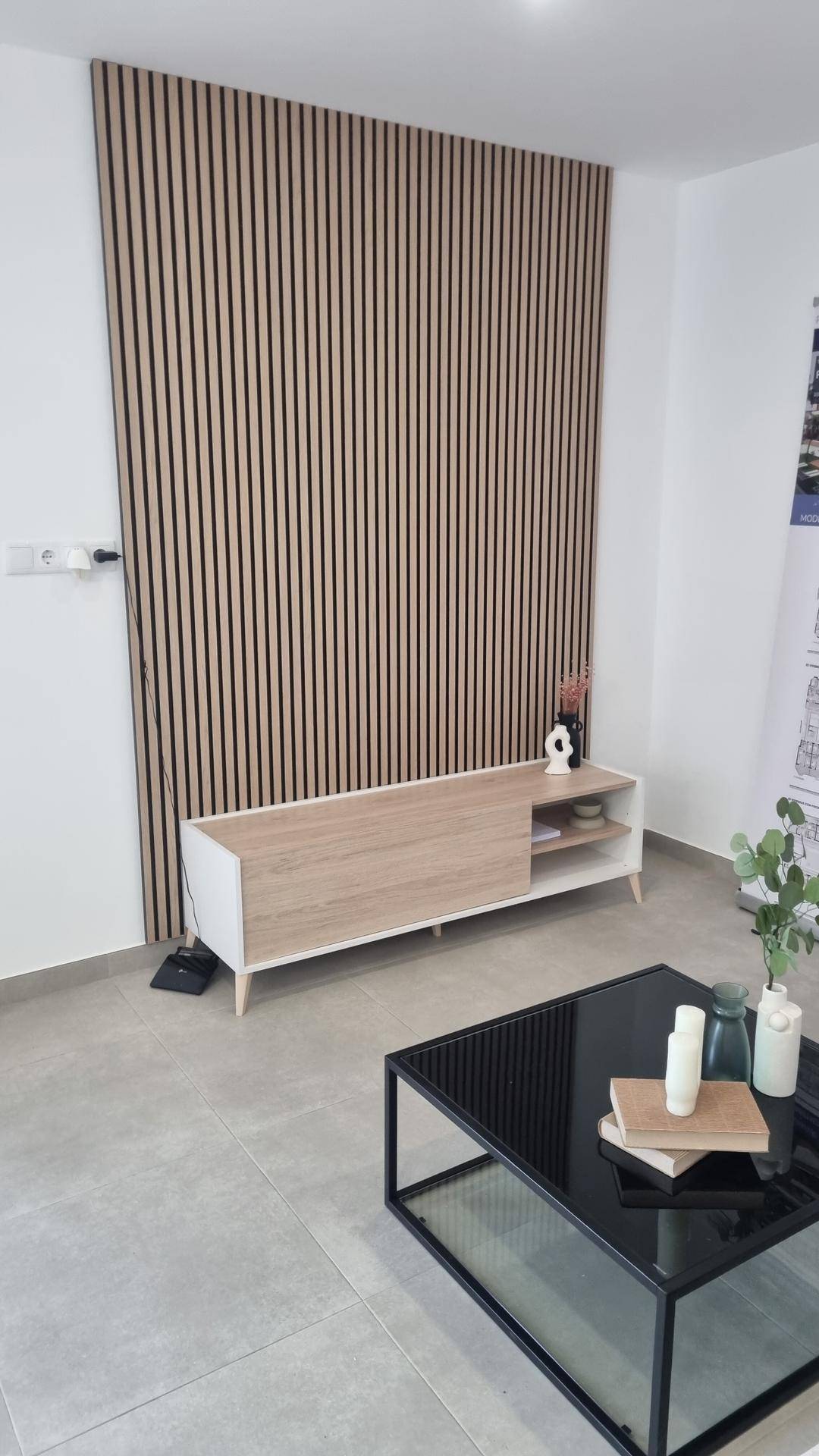 Wohnzimmer mit dekorativer Holzlamellenwand und modernem Couchtisch.