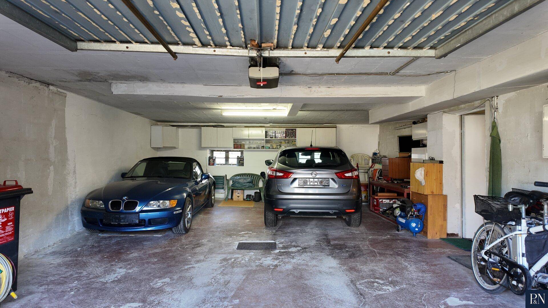 Geräumige Garage mit Platz für zwei Fahrzeuge und zusätzlichem Stauraum.