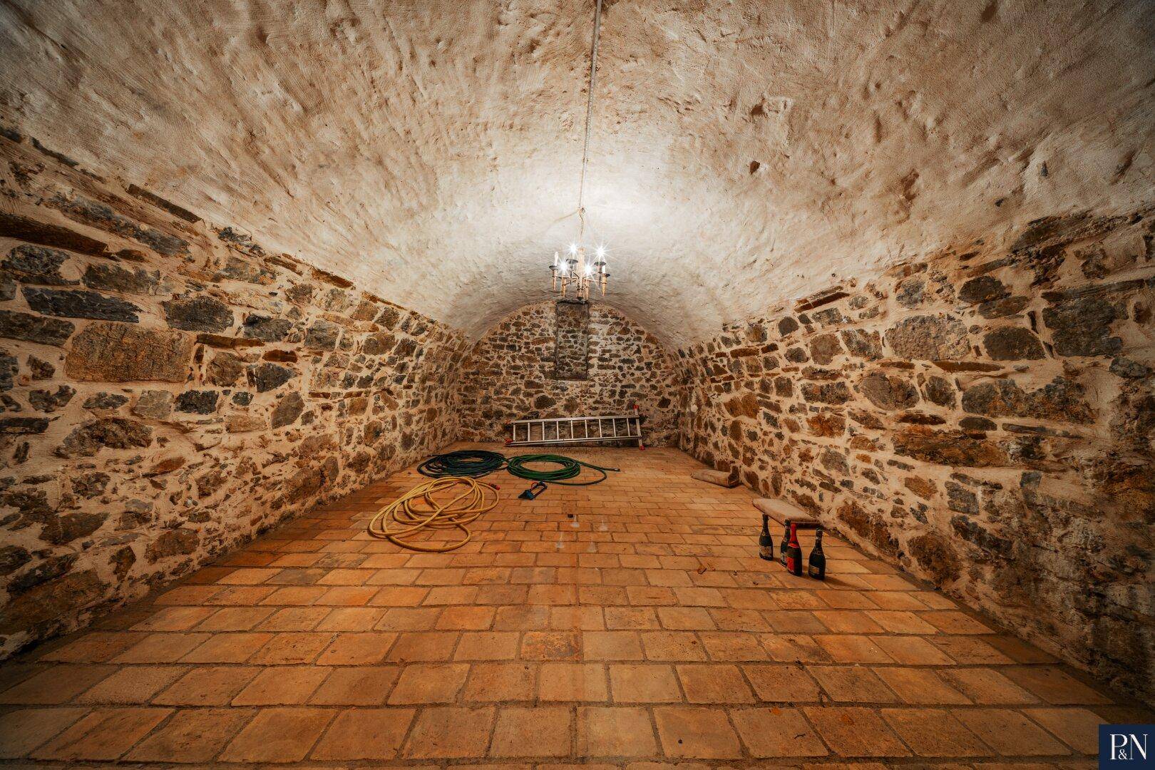 Historischer Kellerraum mit Steinmauern, Gewölbedecke und rustikalem Ambiente.