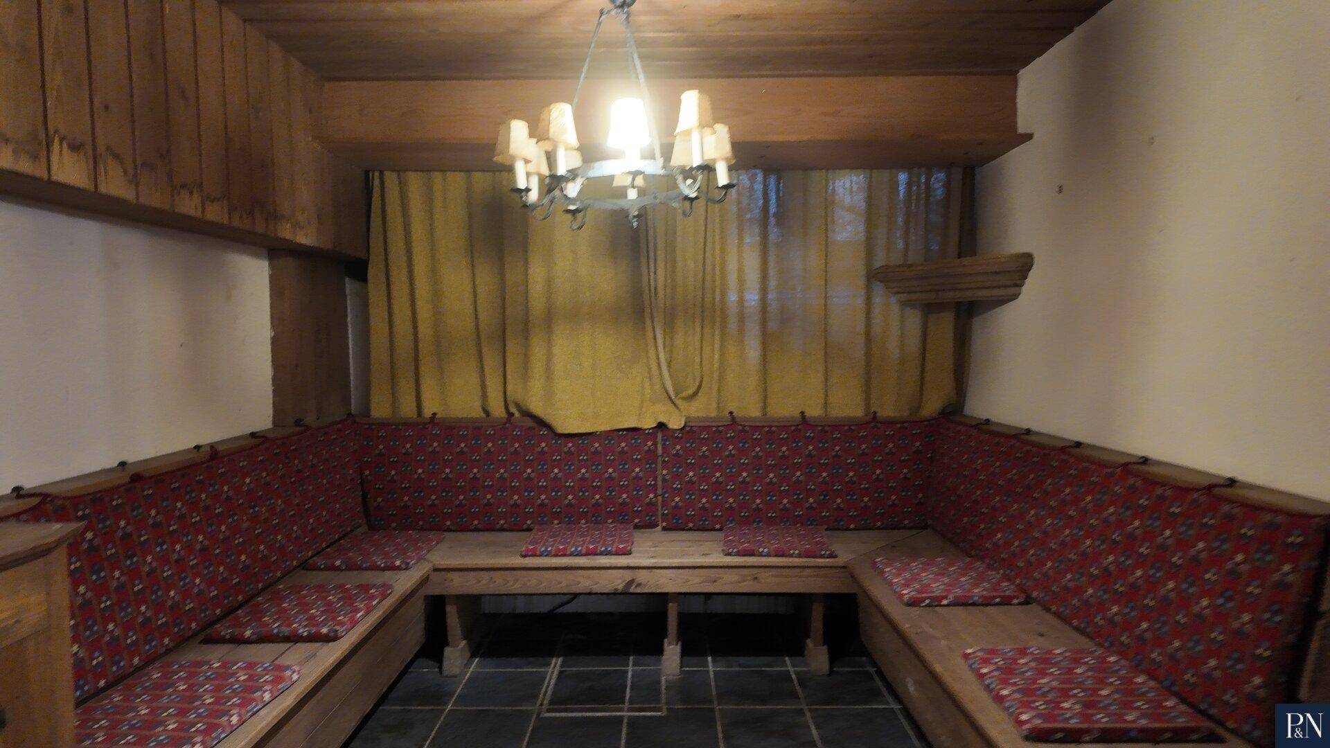 Gemütlicher Hobbyraum im Keller mit eingebauten Holzbänken und bequemen Sitzkissen.