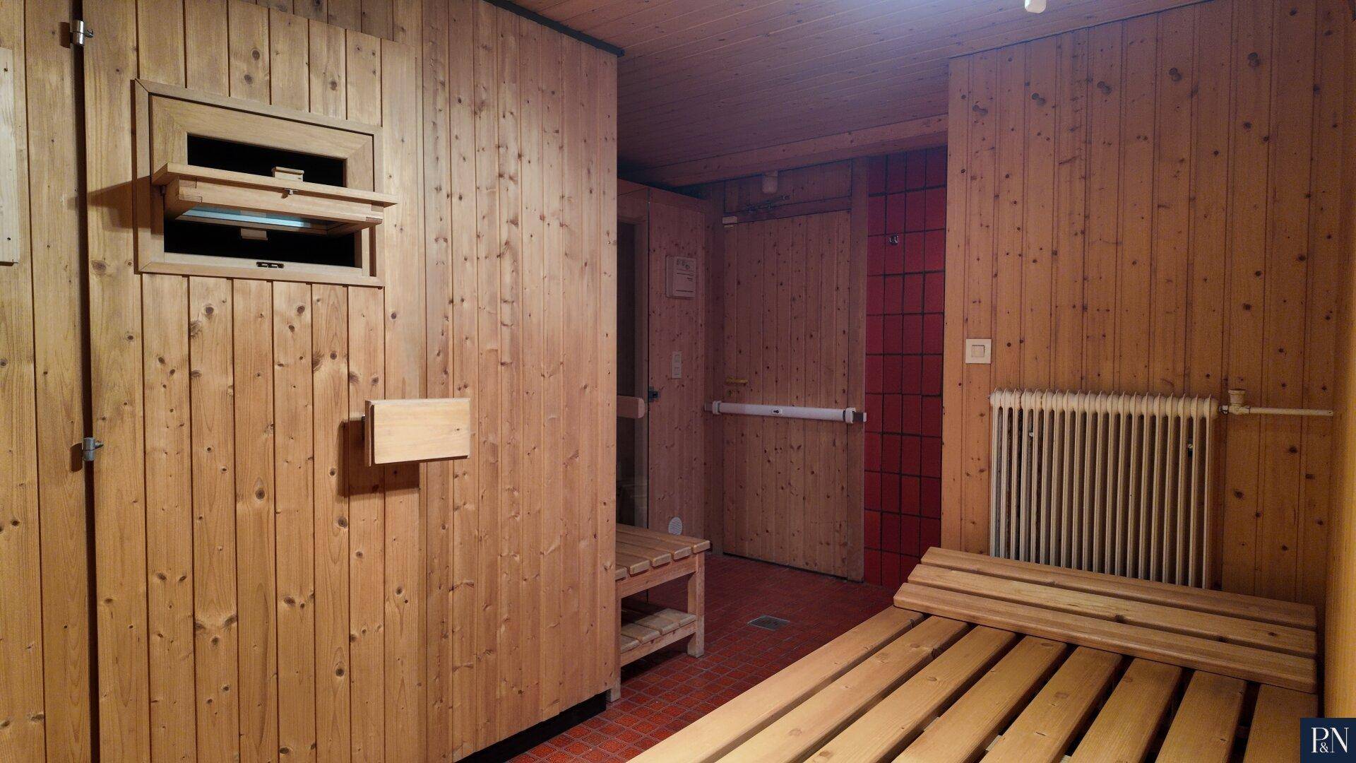 Traditionelle Sauna mit Holzverkleidung und Sitzbänken für entspannende Momente.