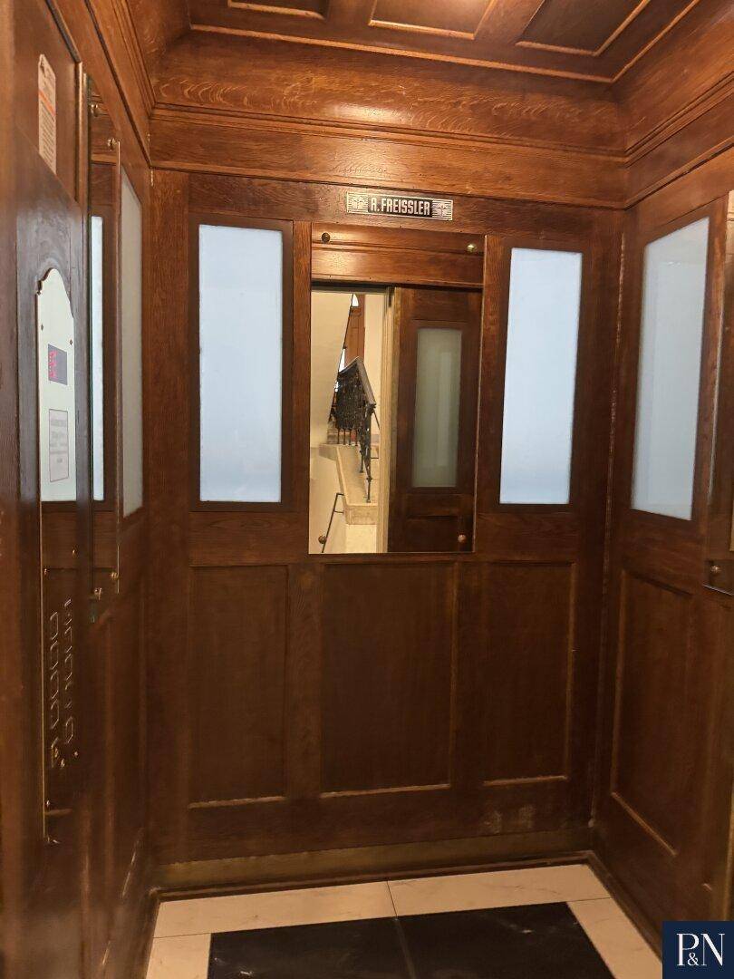 Klassischer Holzaufzug in einem historischen Gebäude mit traditionellem Design.