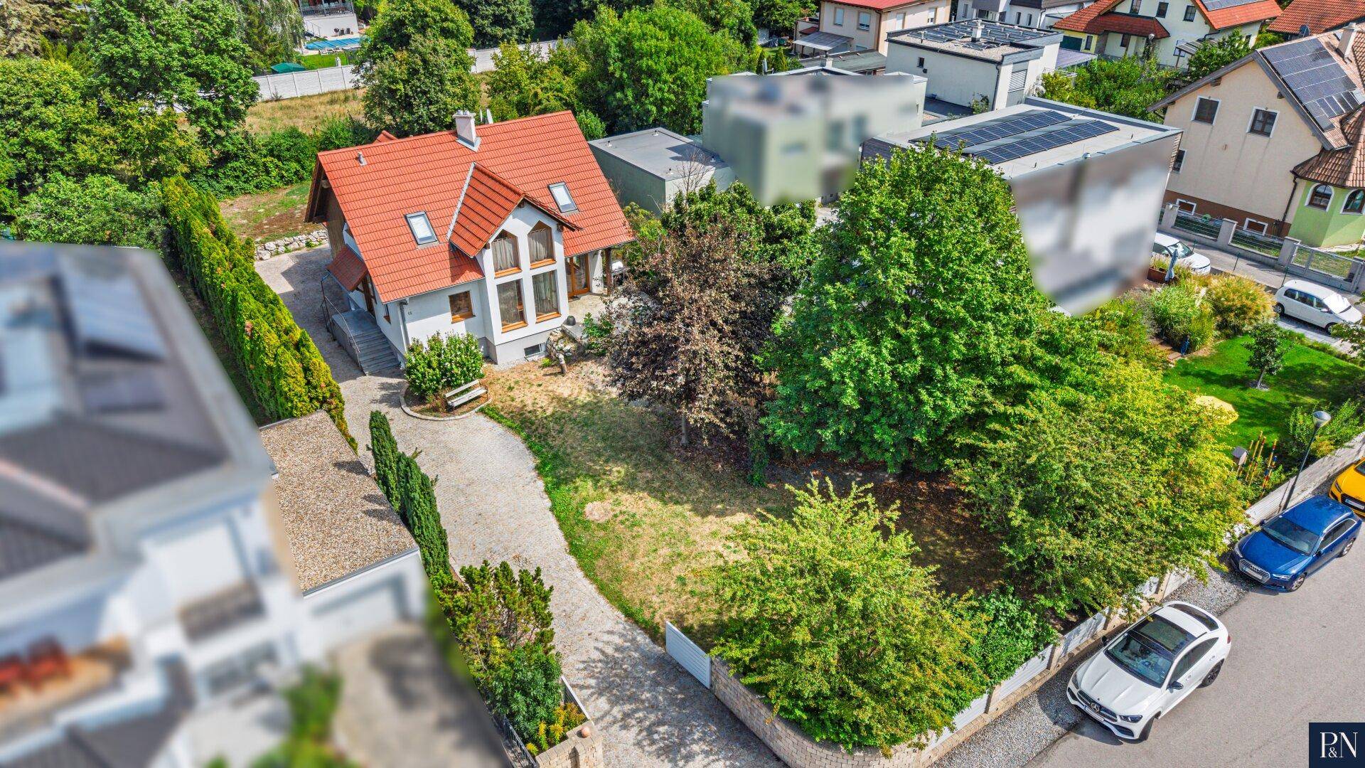 Vogelperspektive des Einfamilienhauses mit großem Garten und umliegender Wohnbebauung.