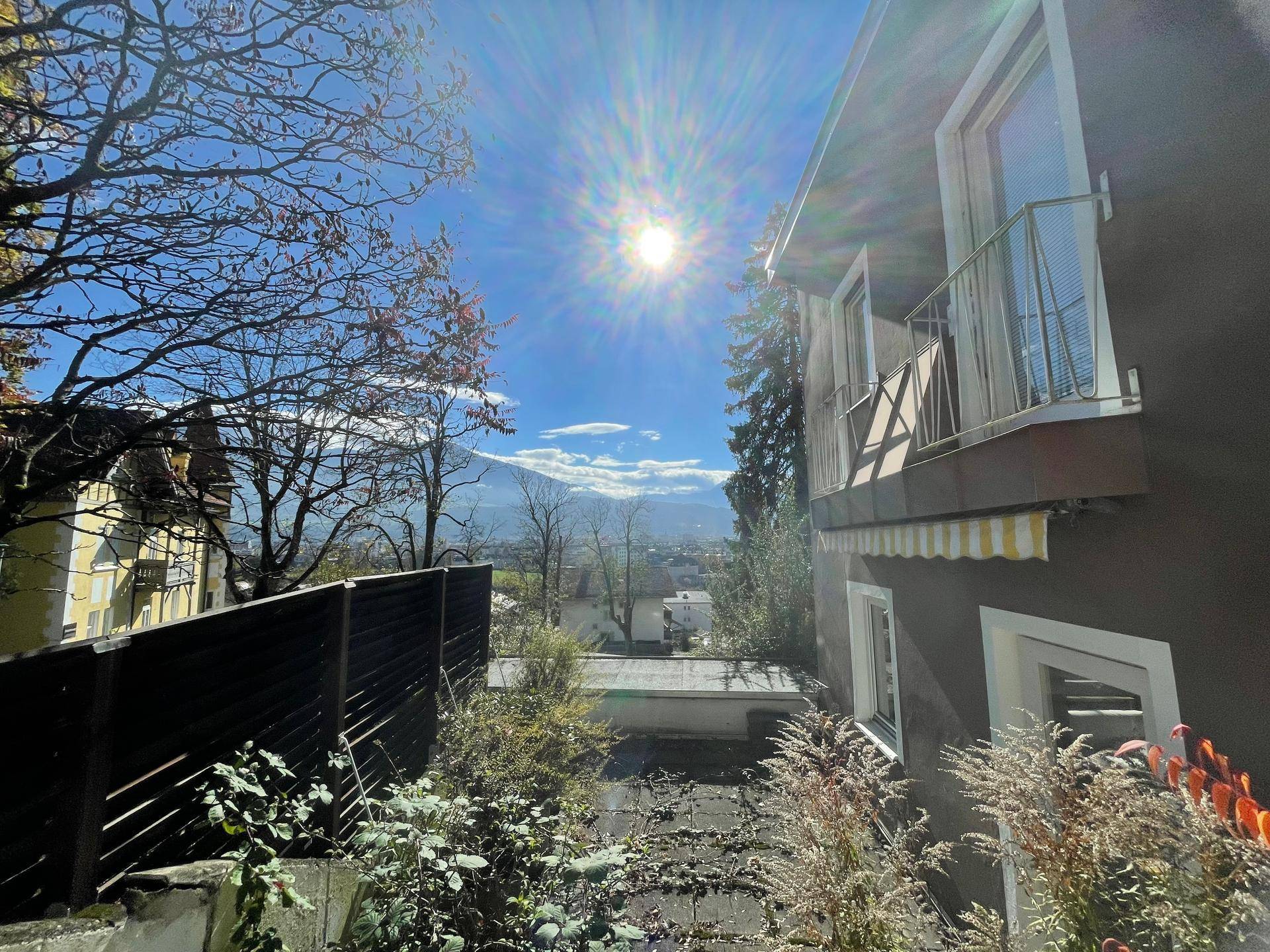 Seitenansicht des Hauses mit Balkon und sonnigem Blick auf die Berge und die weite Landschaft.