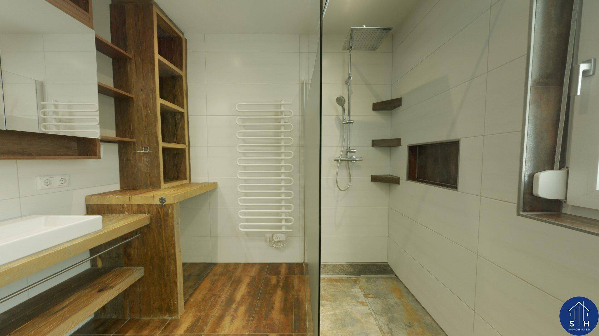 Modernes Badezimmer mit Holzelementen, großem Waschbecken, Spiegelschrank und begehbarer Regendusche.
