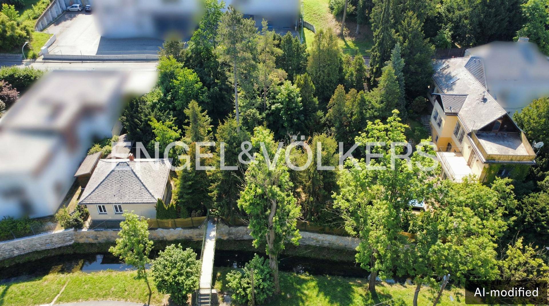 Luftaufnahme der Villa und des weitläufigen Grundstücks mit viel Grün und angrenzenden Gebäuden.