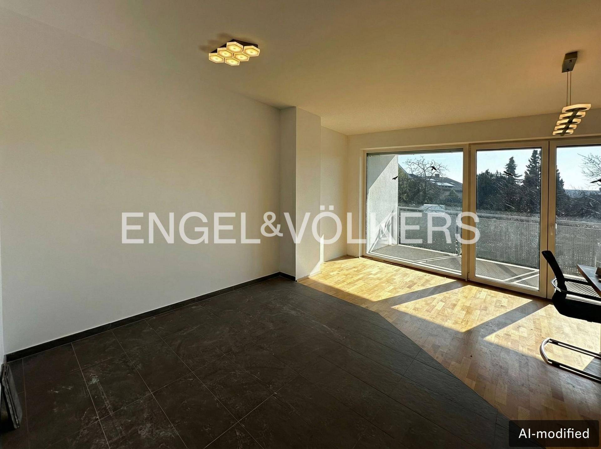 Geräumiger Wohnbereich mit Holzboden und großen Fenstern, die den Raum erhellen.