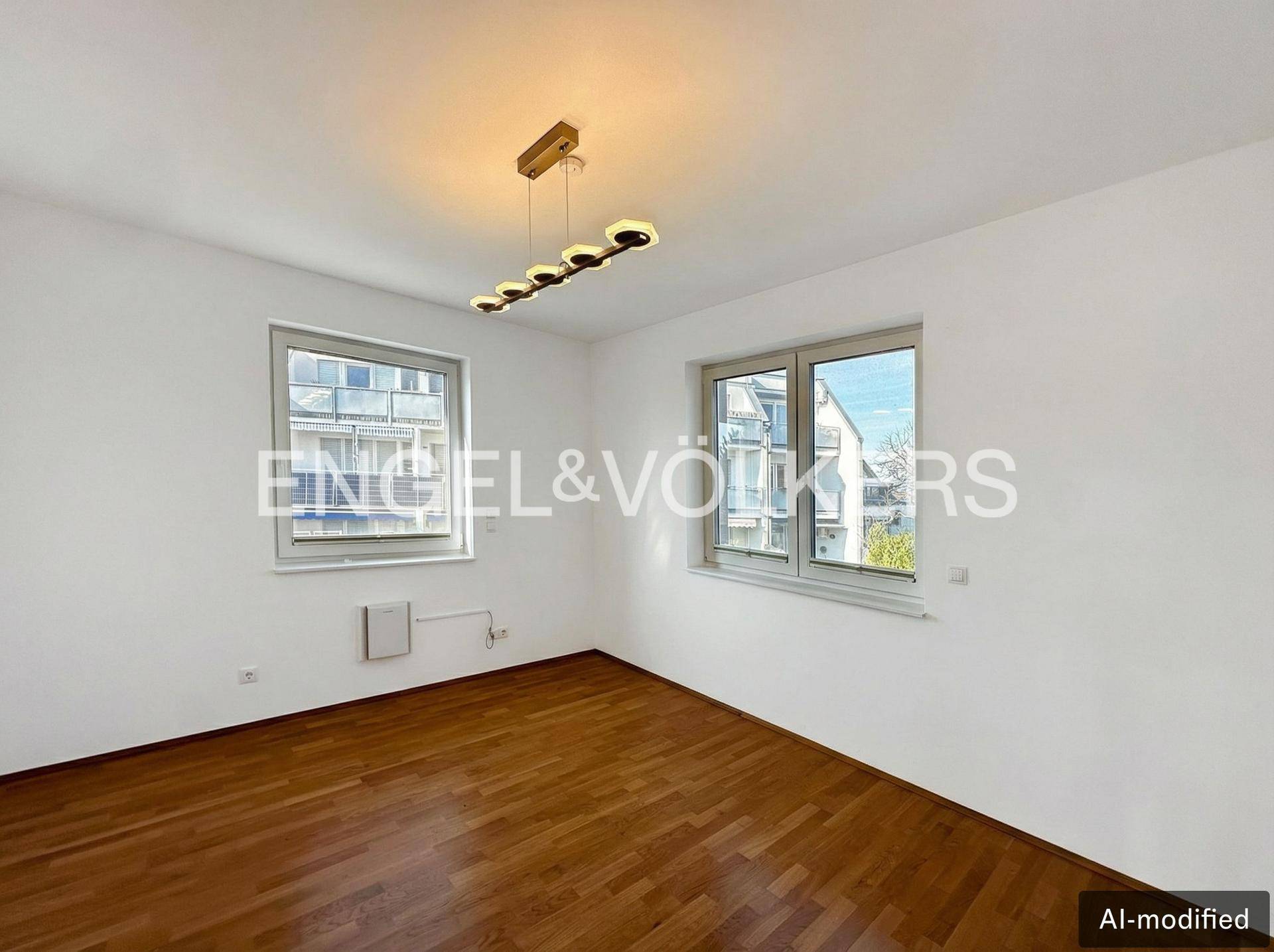 Helles Schlafzimmer mit Holzboden und großen Fenstern, bereit zur individuellen Gestaltung.