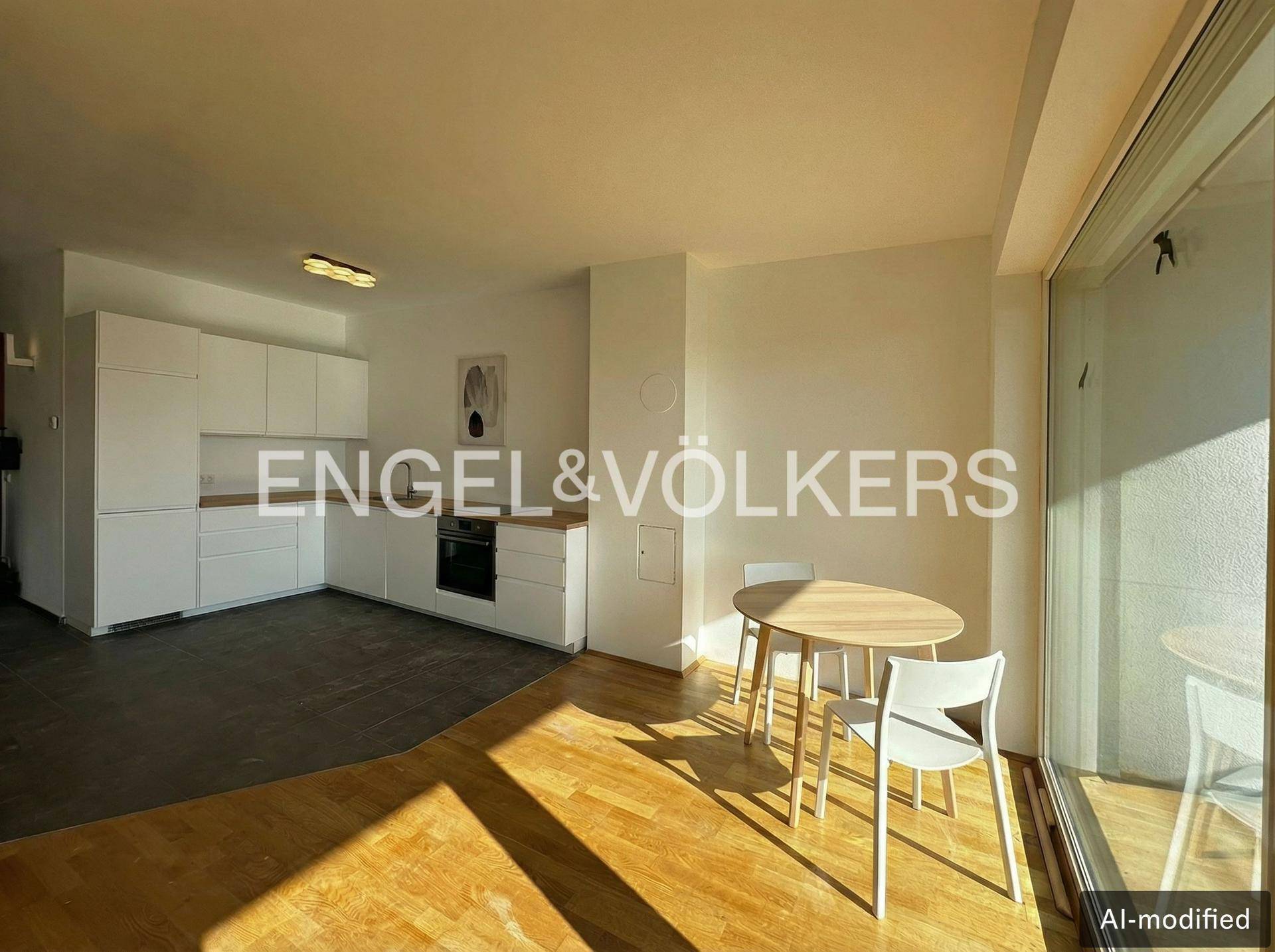 Offene Küche mit weißen Schränken und Essbereich, verbunden mit einem hellen Wohnraum.