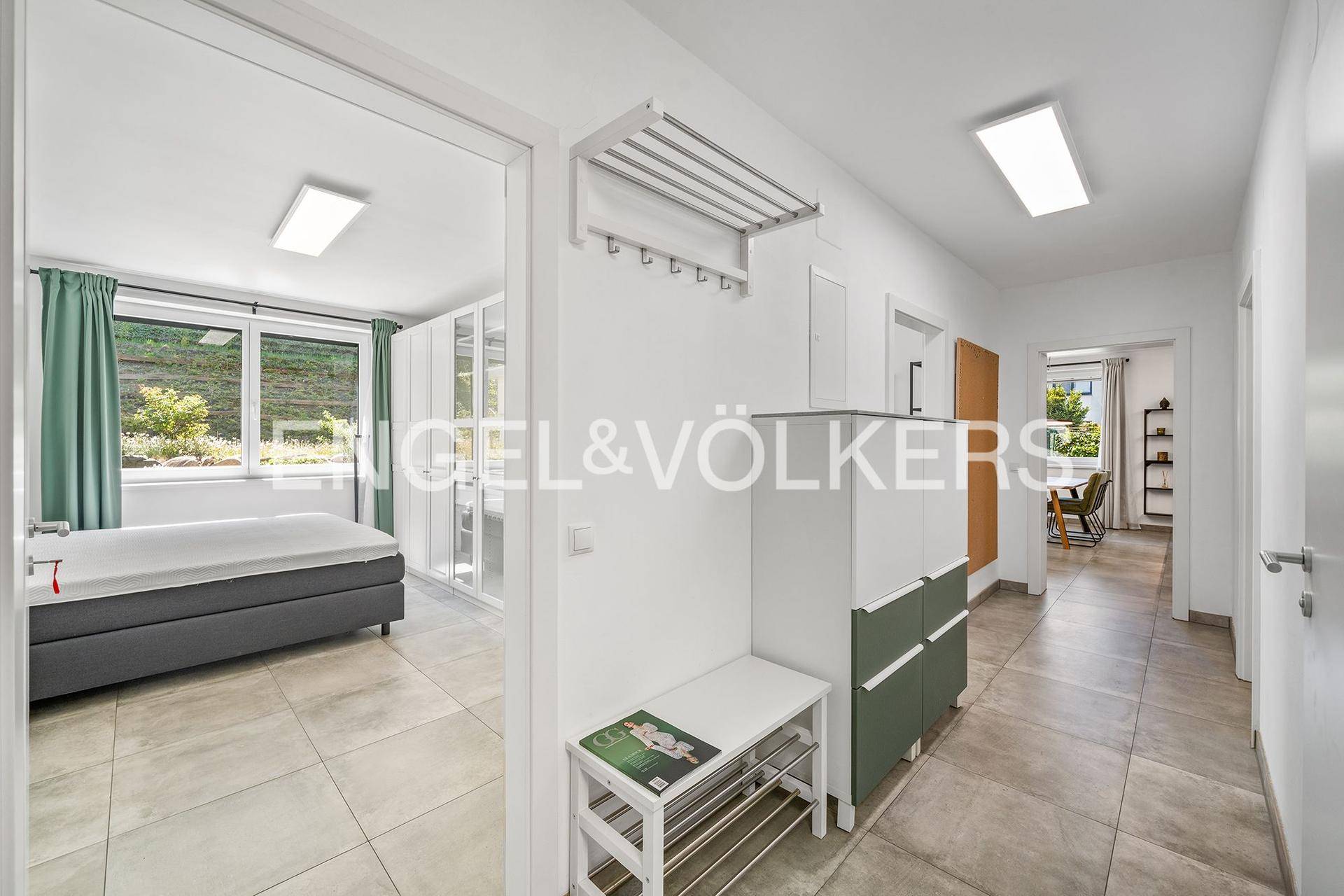 Heller Flur mit Fliesenboden, Garderobe und Blick in angrenzende Wohnbereiche.