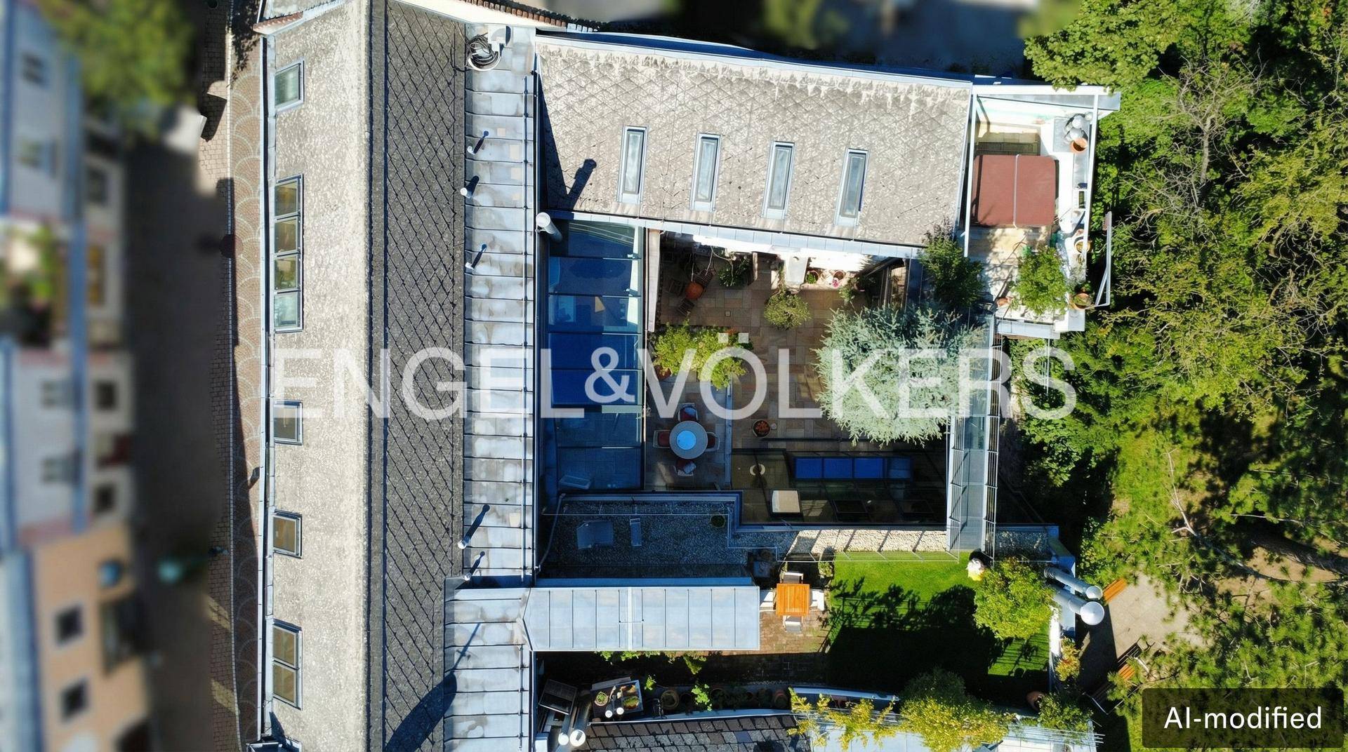 Luftaufnahme eines Anwesens mit Innenhof, Dachterrassen und begrünten Flächen.