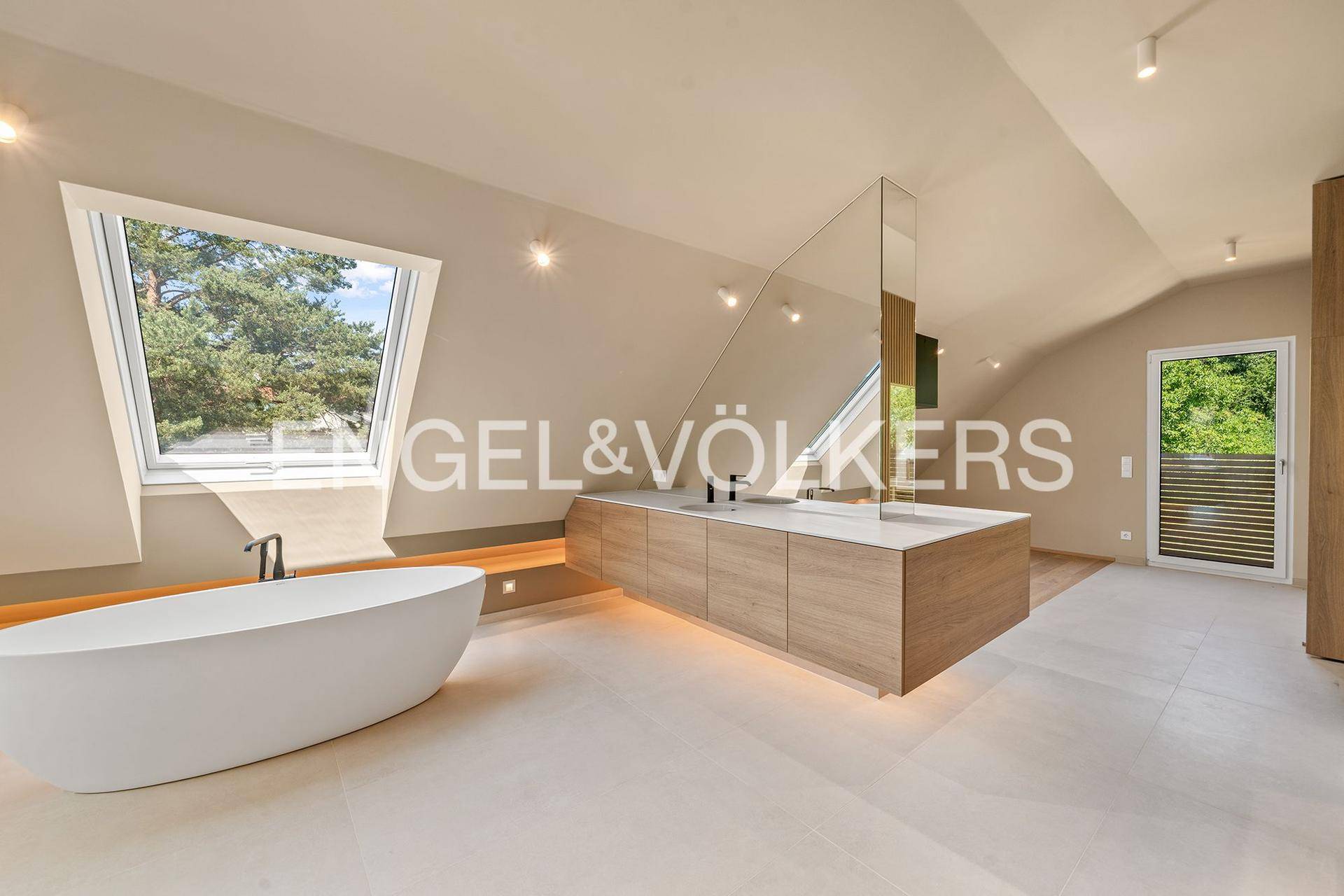 Modernes Badezimmer im Dachgeschoss mit freistehender Badewanne, Doppelwaschbecken und Dachfenster.