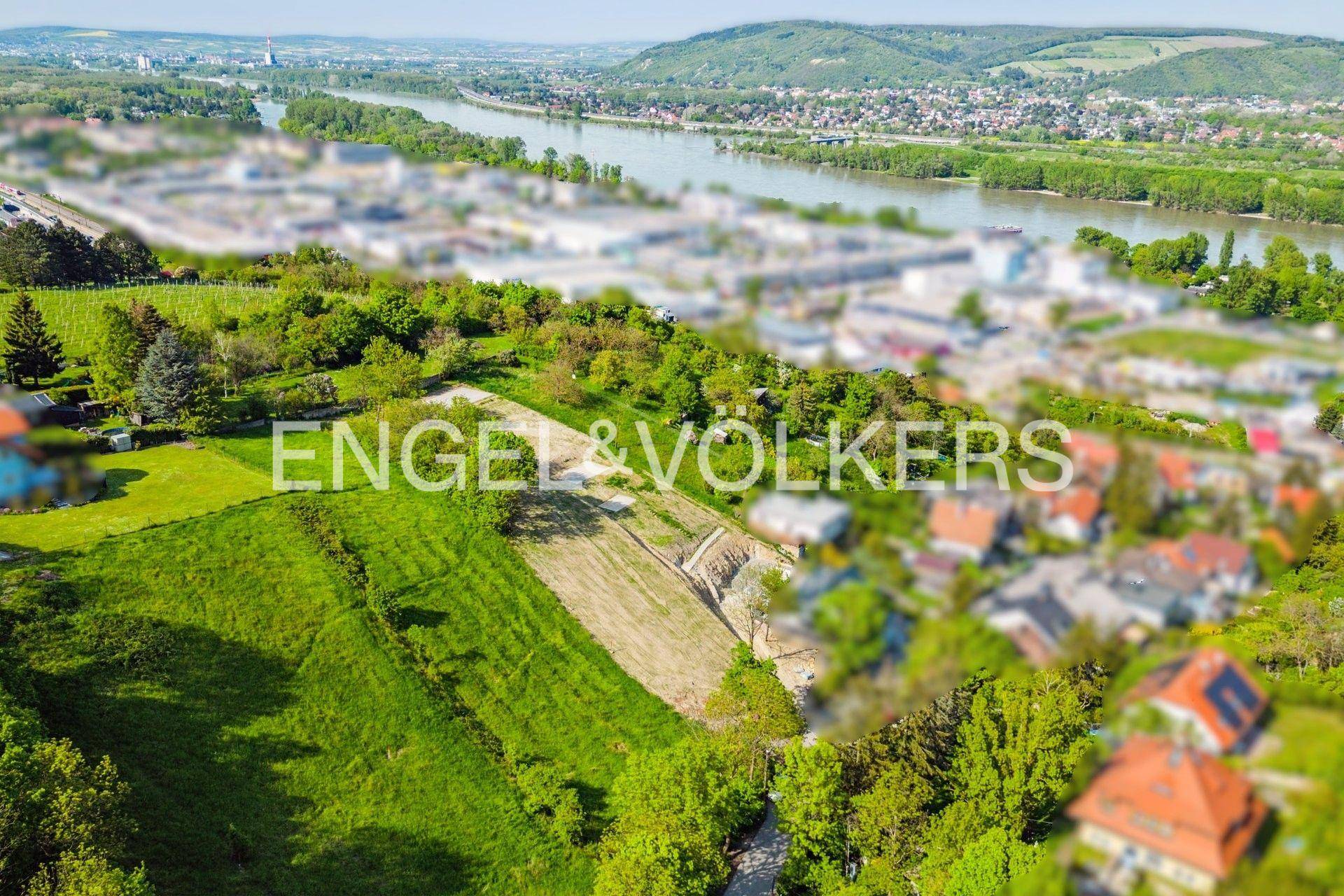 Luftaufnahme eines Hanggrundstücks mit Blick auf die Donau und umliegende Wohngebiete.
