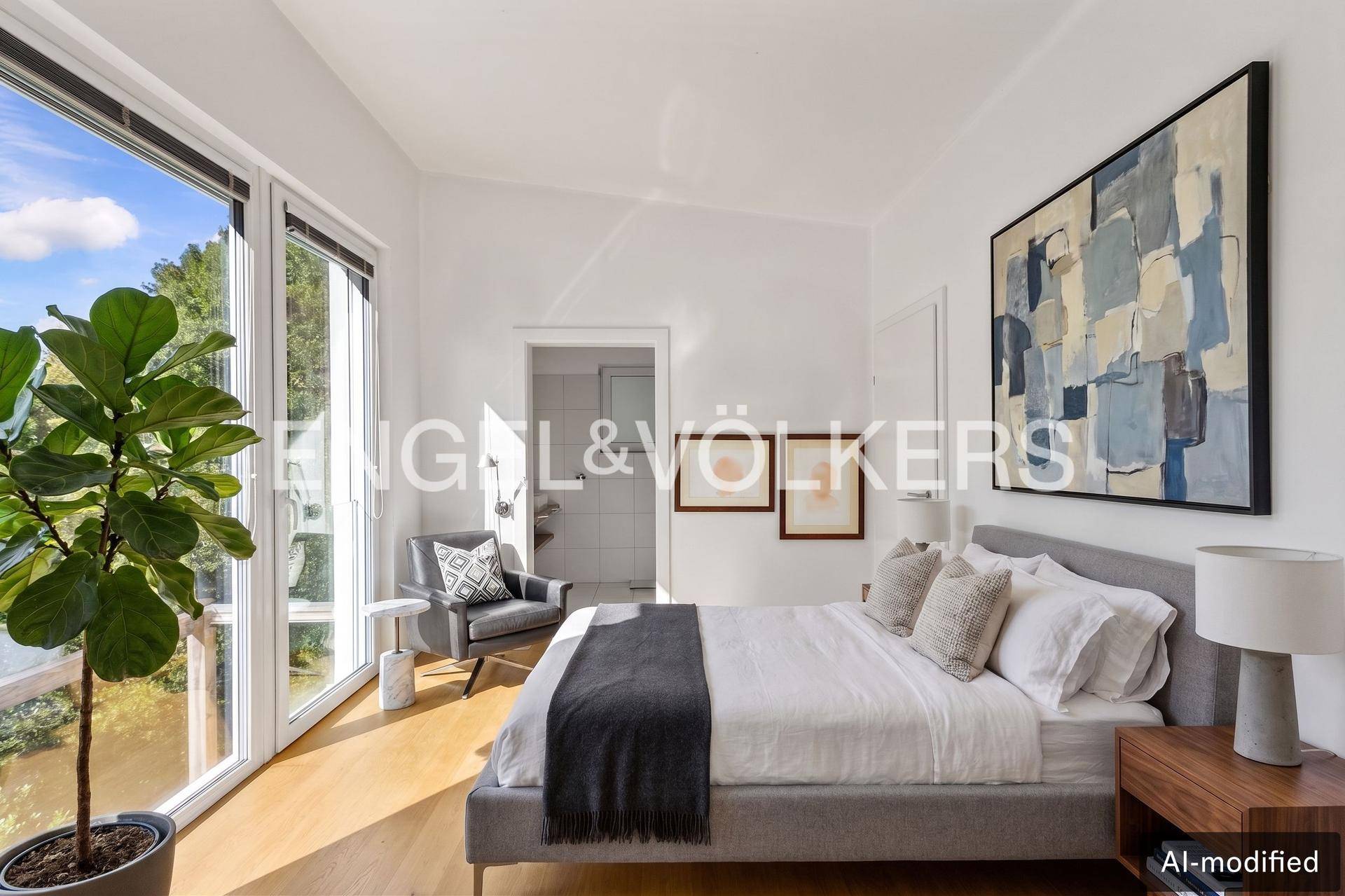 Modernes Schlafzimmer mit Holzboden, großen Fenstern und Zugang zu einem eigenen Bad.