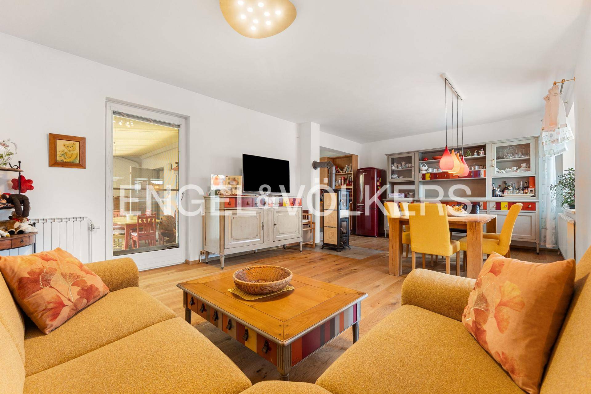 Gemütlicher Wohnbereich mit gelbem Sofa, Couchtisch und Blick in den Essbereich.