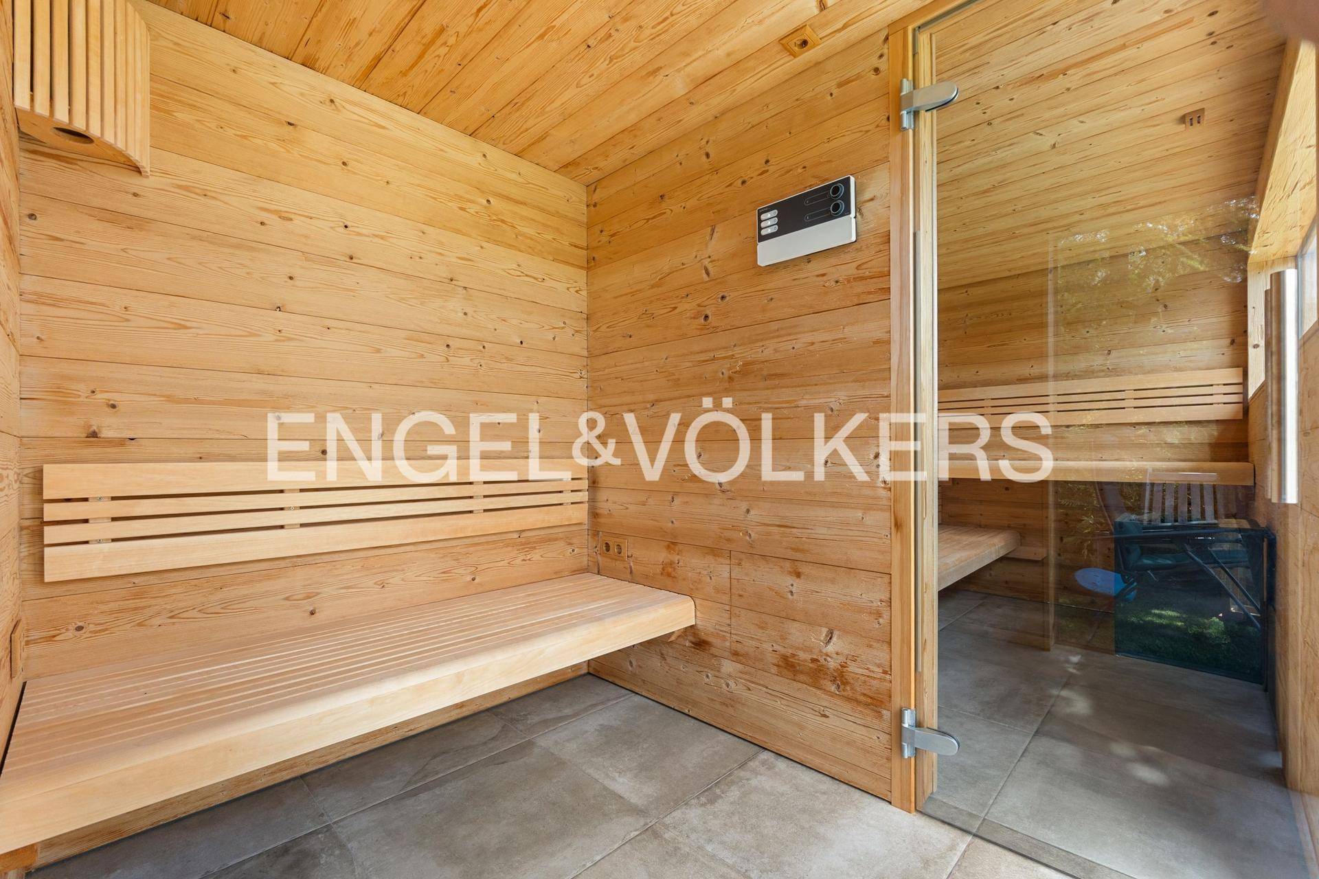 Gemütliche Holzsauna mit Bänken und Steuerungselementen für entspannende Momente.