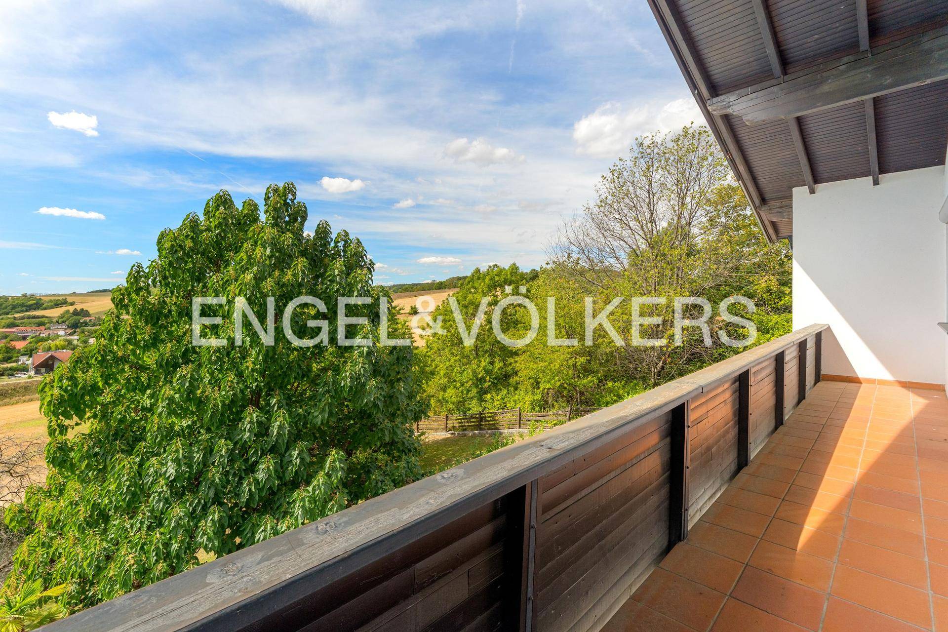 Geräumiger Balkon mit Terrakottafliesen und weitem Blick über die Landschaft.