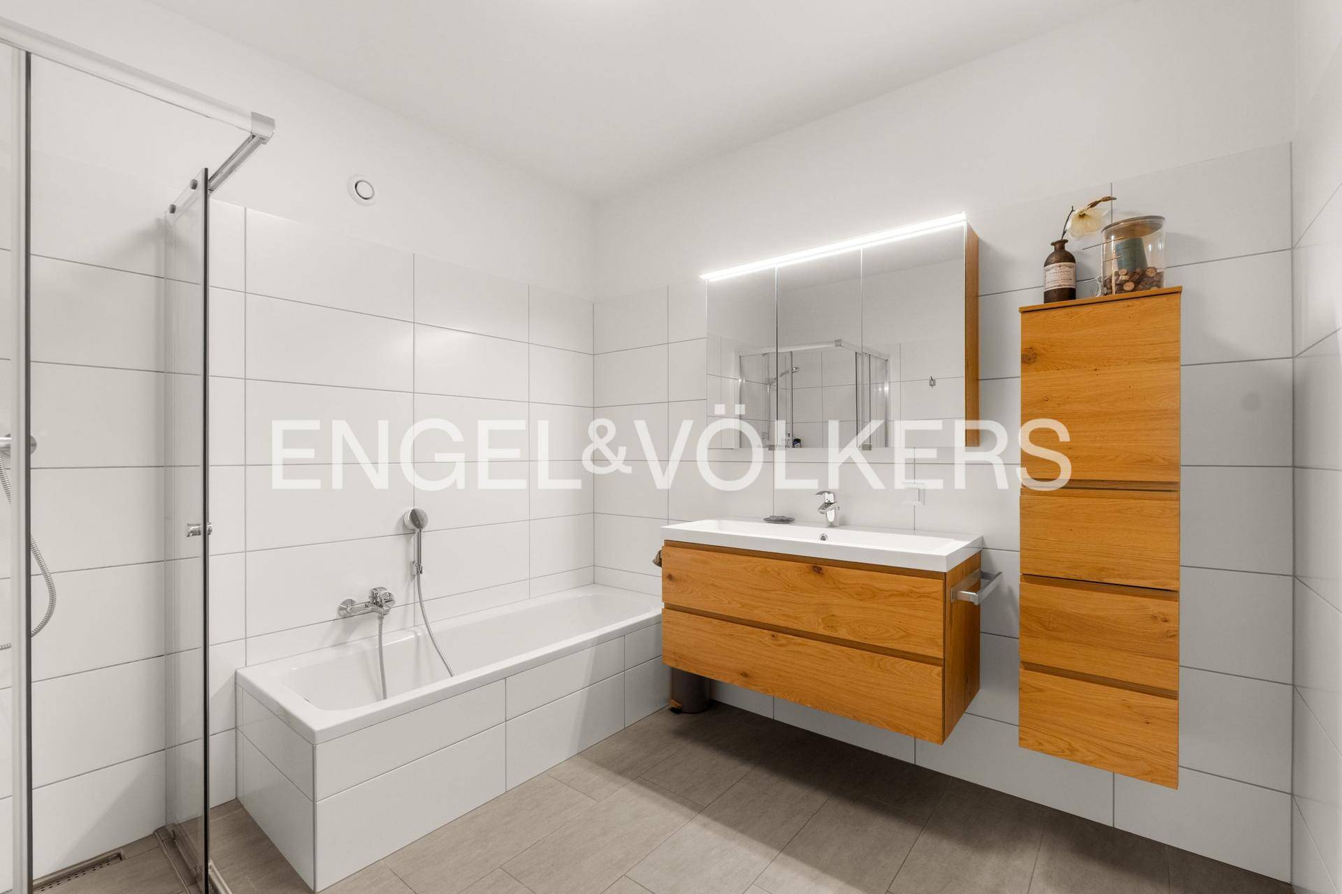 Modernes Badezimmer mit Badewanne, Dusche und Holzwaschtisch mit Spiegelschrank.