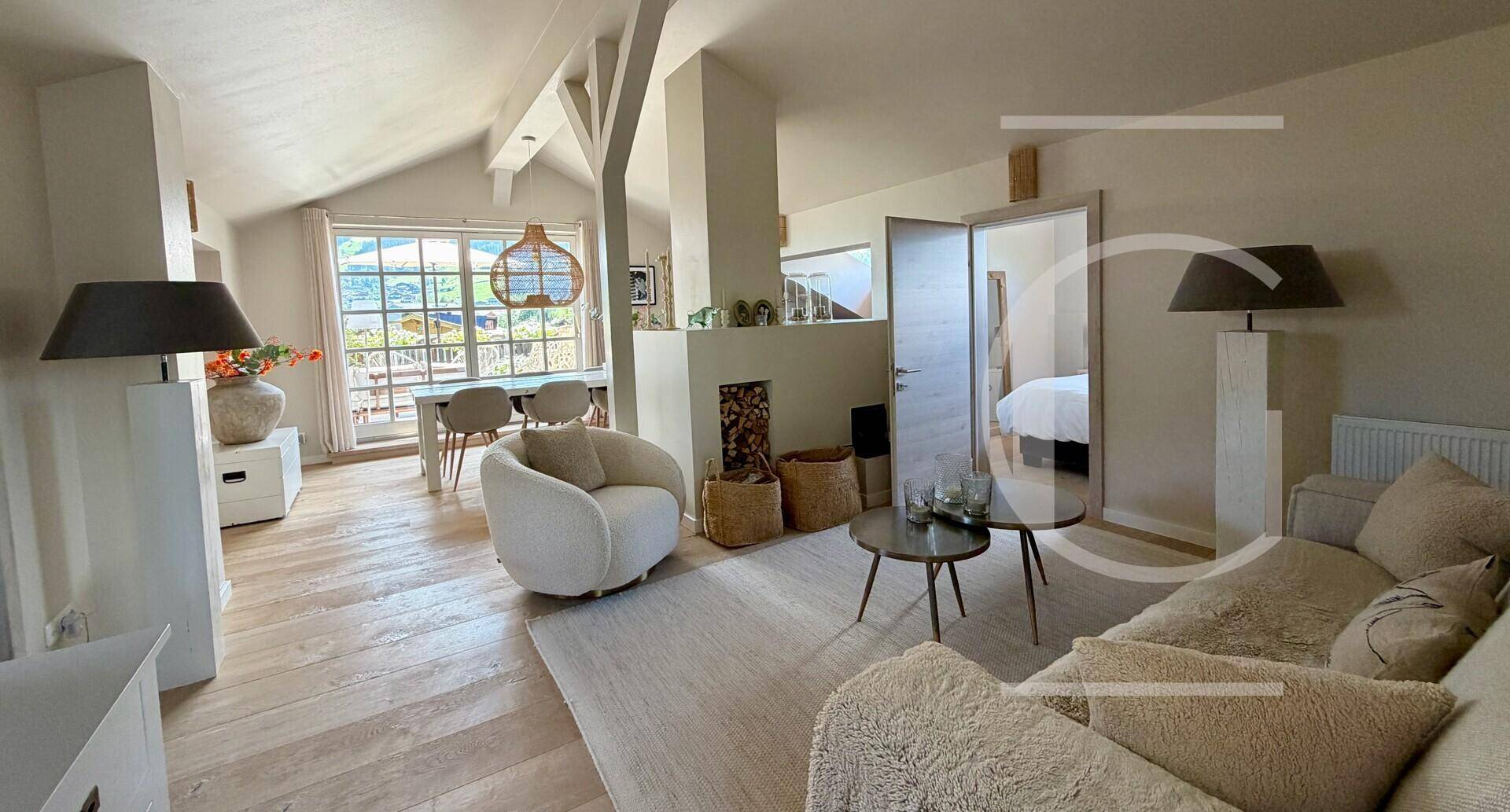 Heller, offener Wohn- und Essbereich mit Holzboden, Dachschrägen und Zugang zum Schlafzimmer.